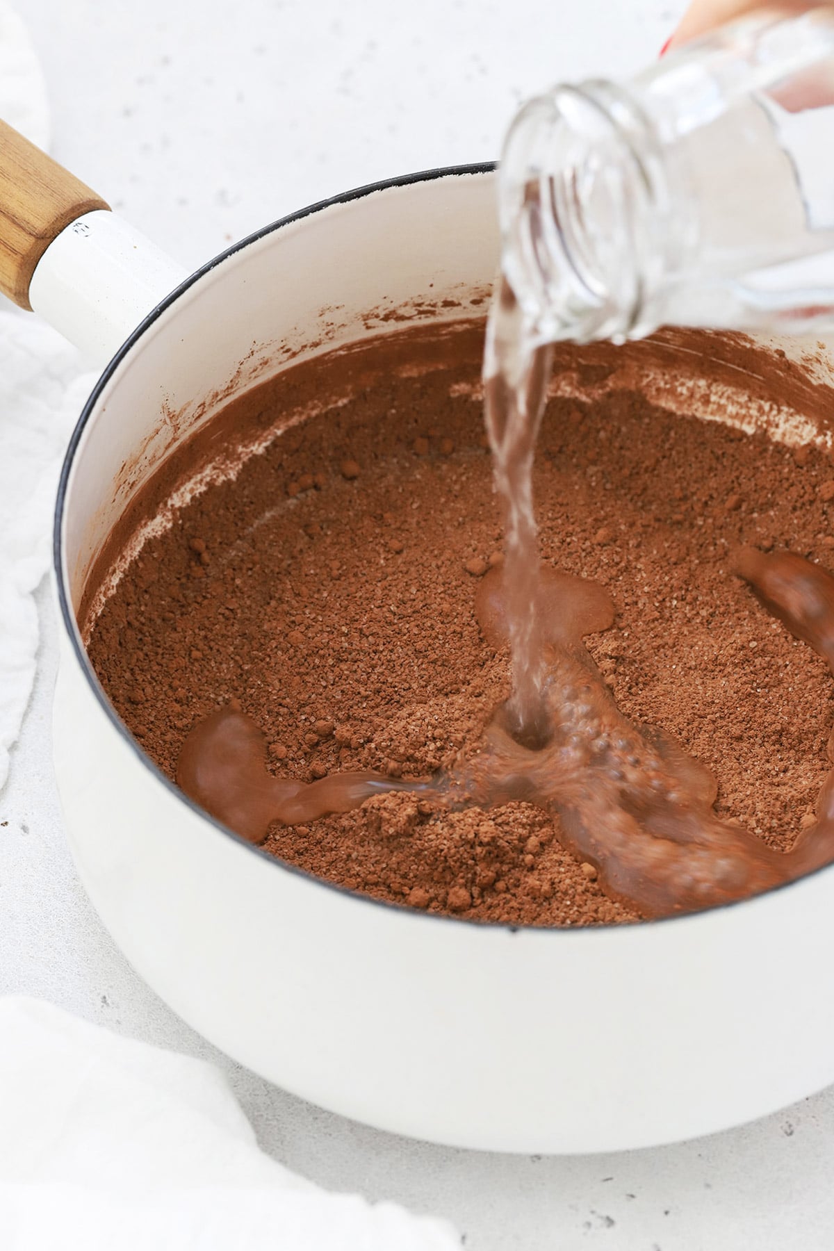 adding water to the dry ingredients to make homemade chocolate syrup