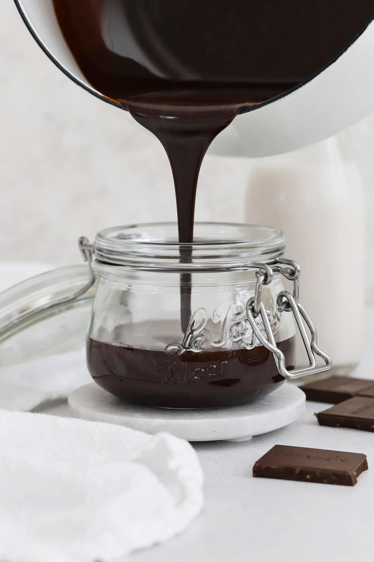 Pouring homemade chocolate syrup into a jar