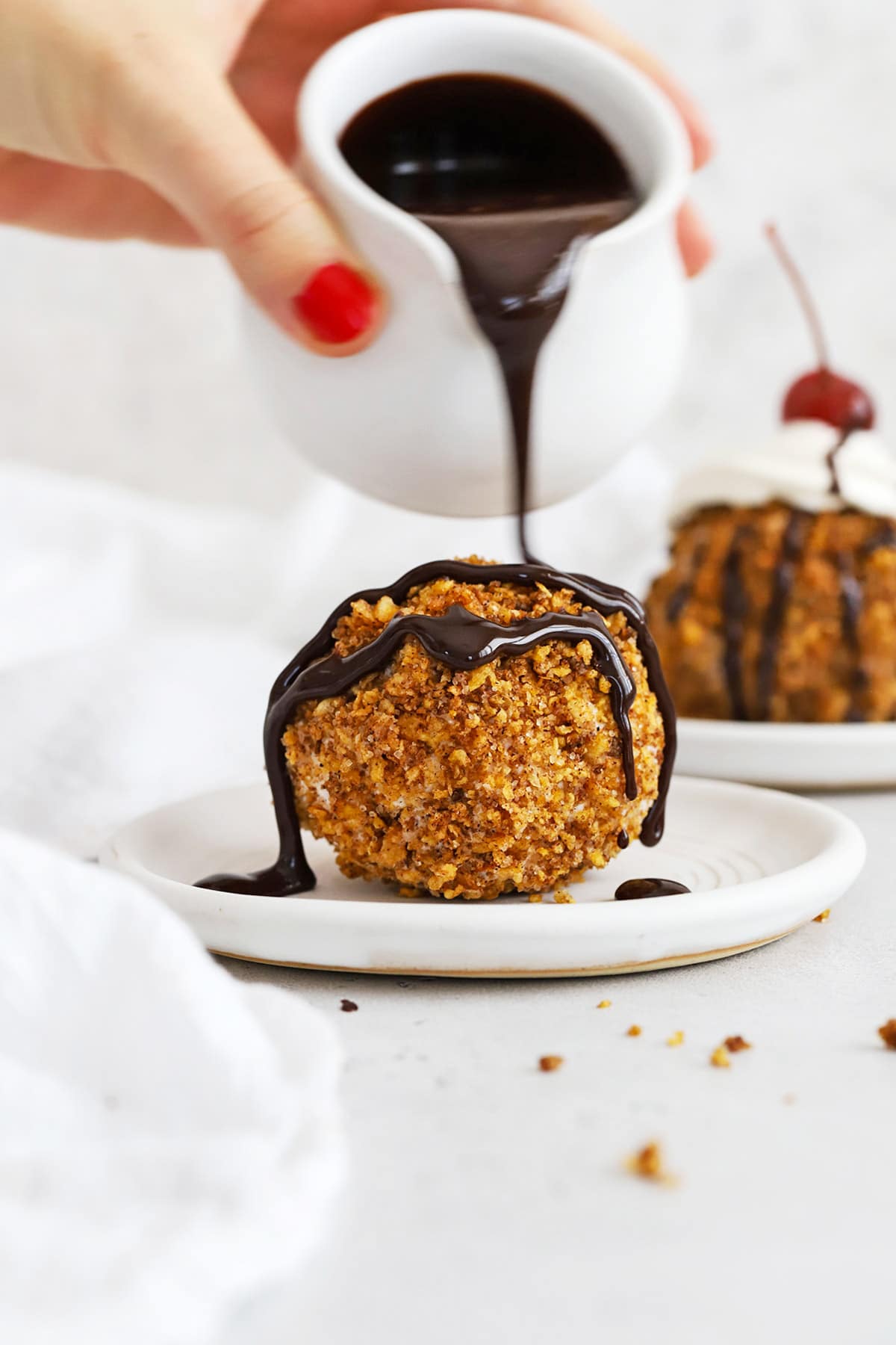 Drizzling chocolate sauce over a scoop of gluten-free fried ice cream