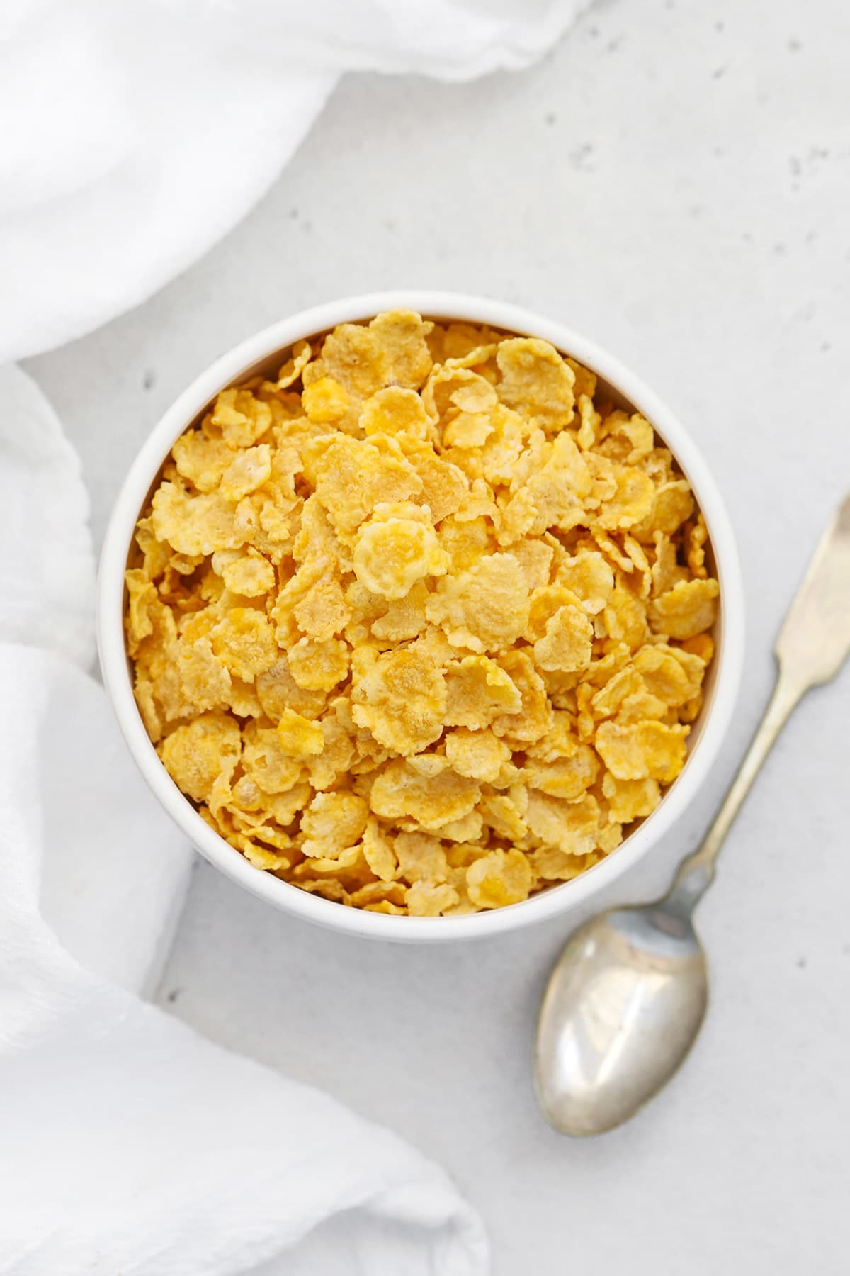 Overhead view of a white bowl of gluten free corn flakes