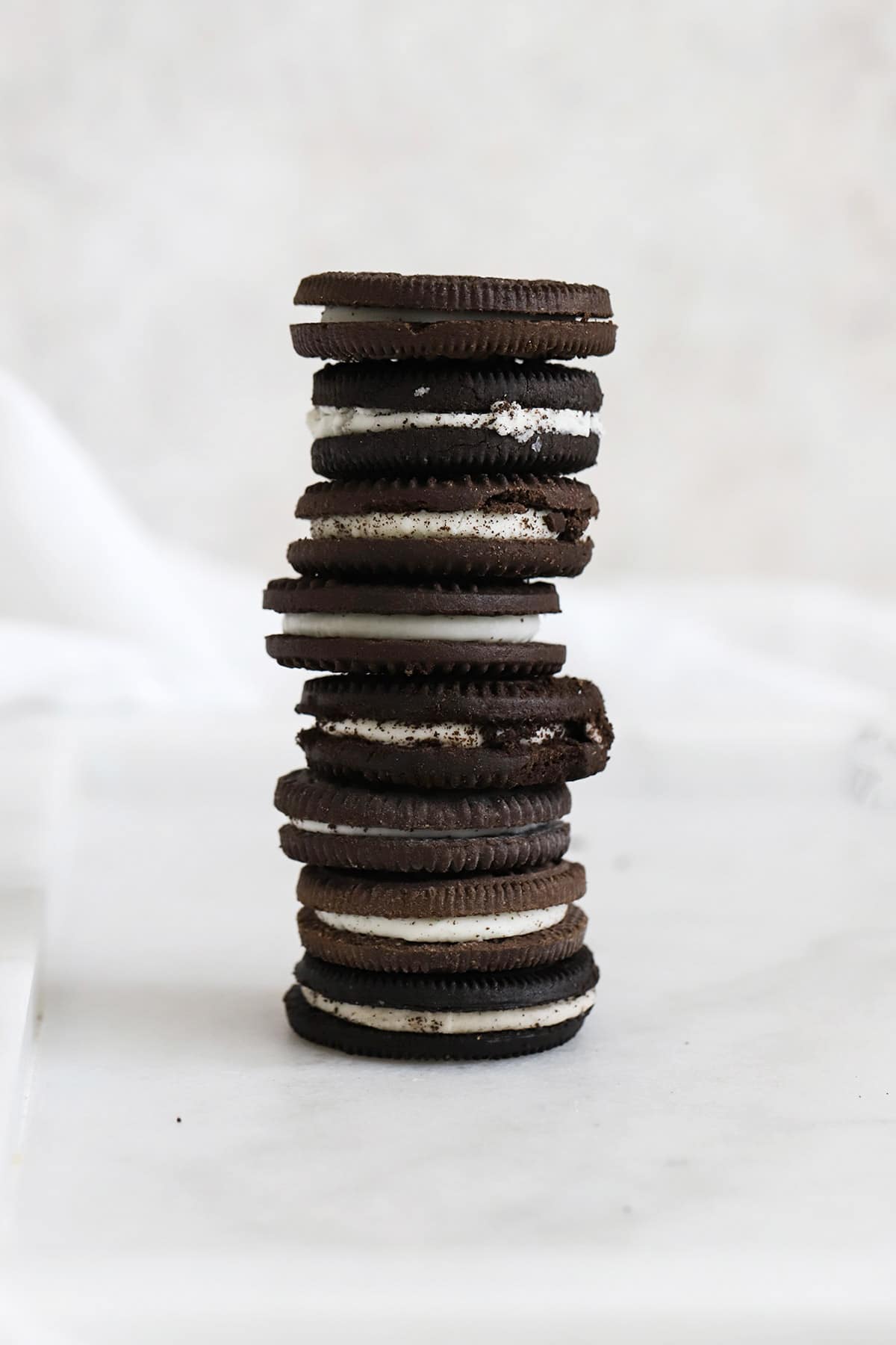 Front view of a stack of 8 kinds of gluten-free chocolate sandwich cookies