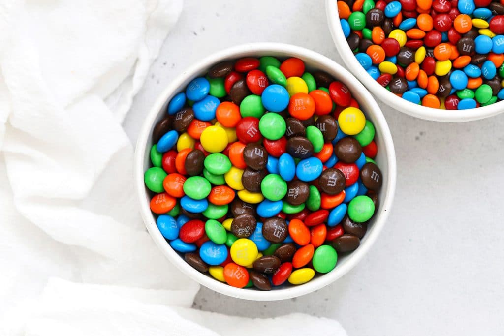 Overhead view of colorful m&ms in a white bowl