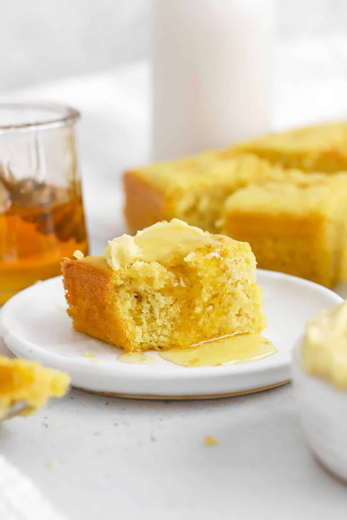 Gluten-free cornbread being drizzled with honey