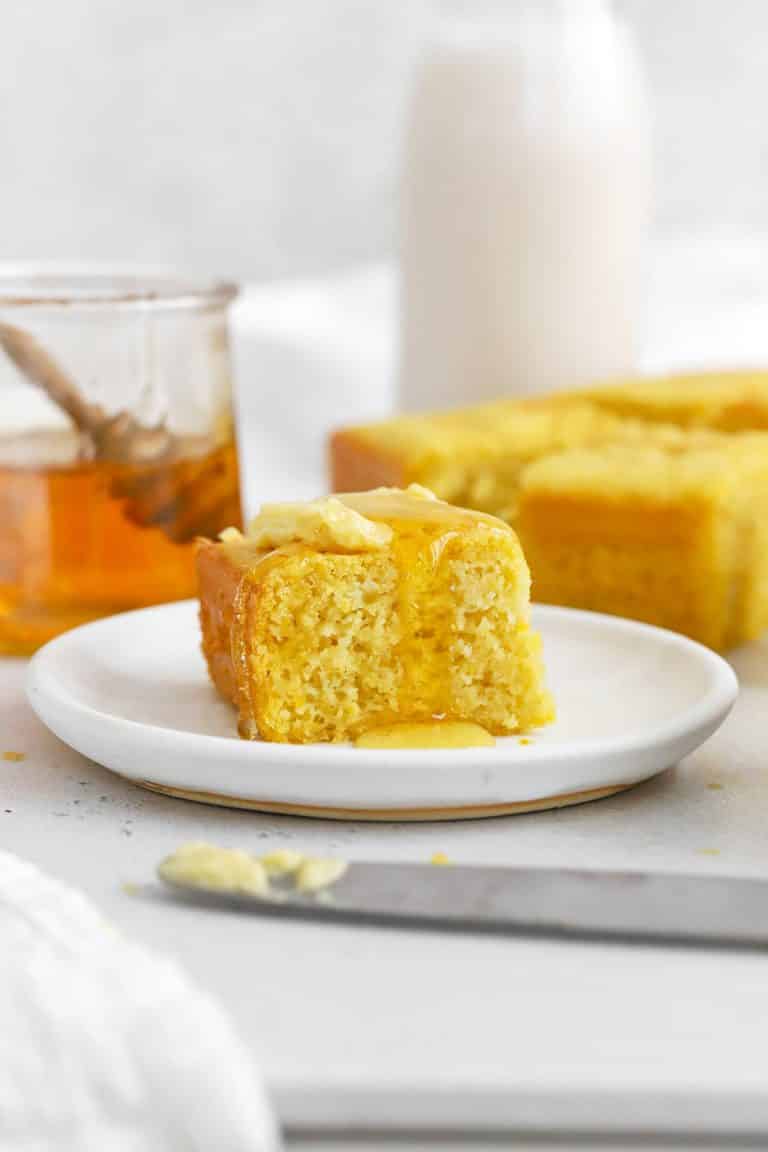 Front view of a slice of easy gluten-free cornbread topped with honey butter