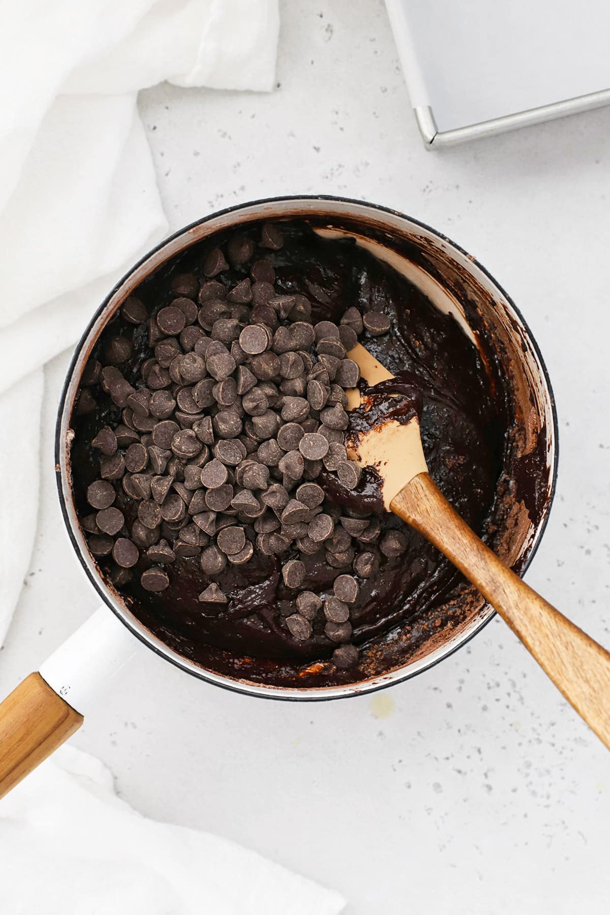 Stirring chocolate chips into gluten-free m&m brownie batter