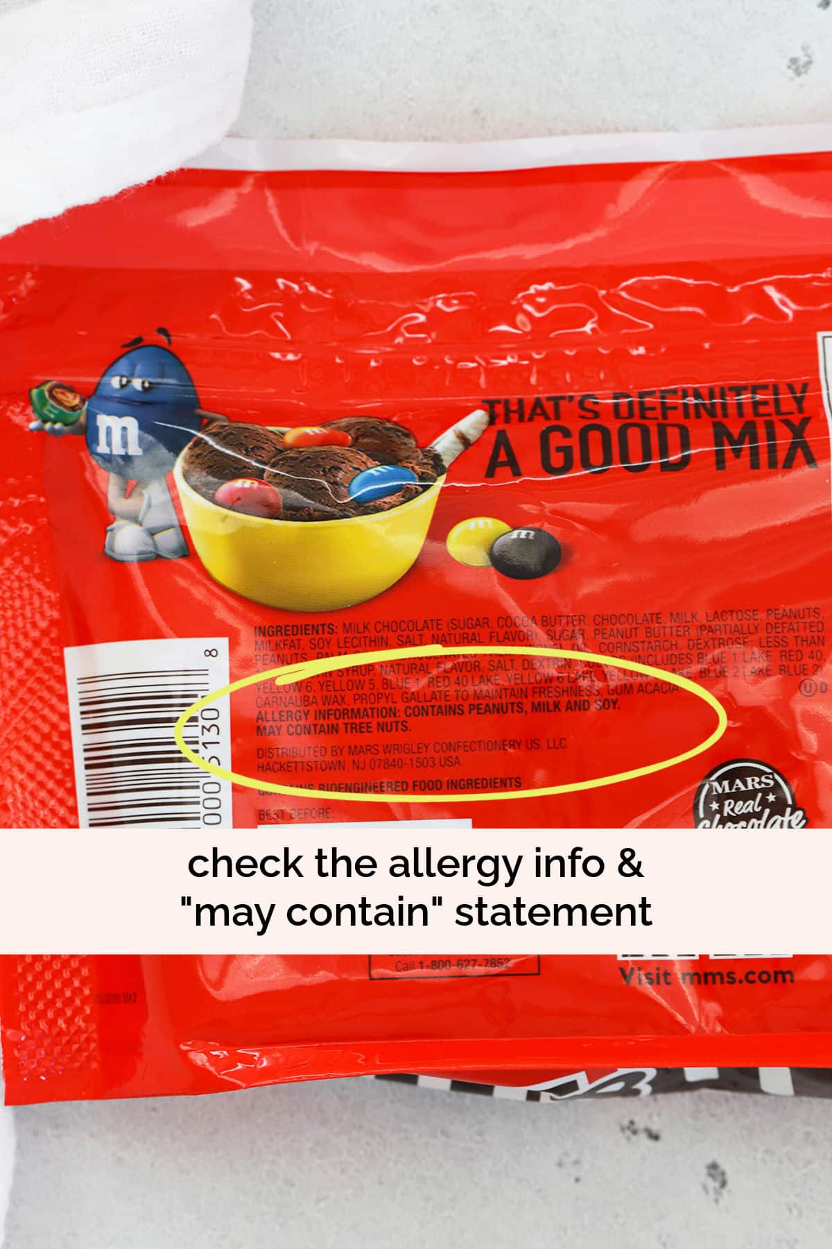yellow circle highlighting the "may contain" statement on the nutrition facts of a bag of peanut m&ms