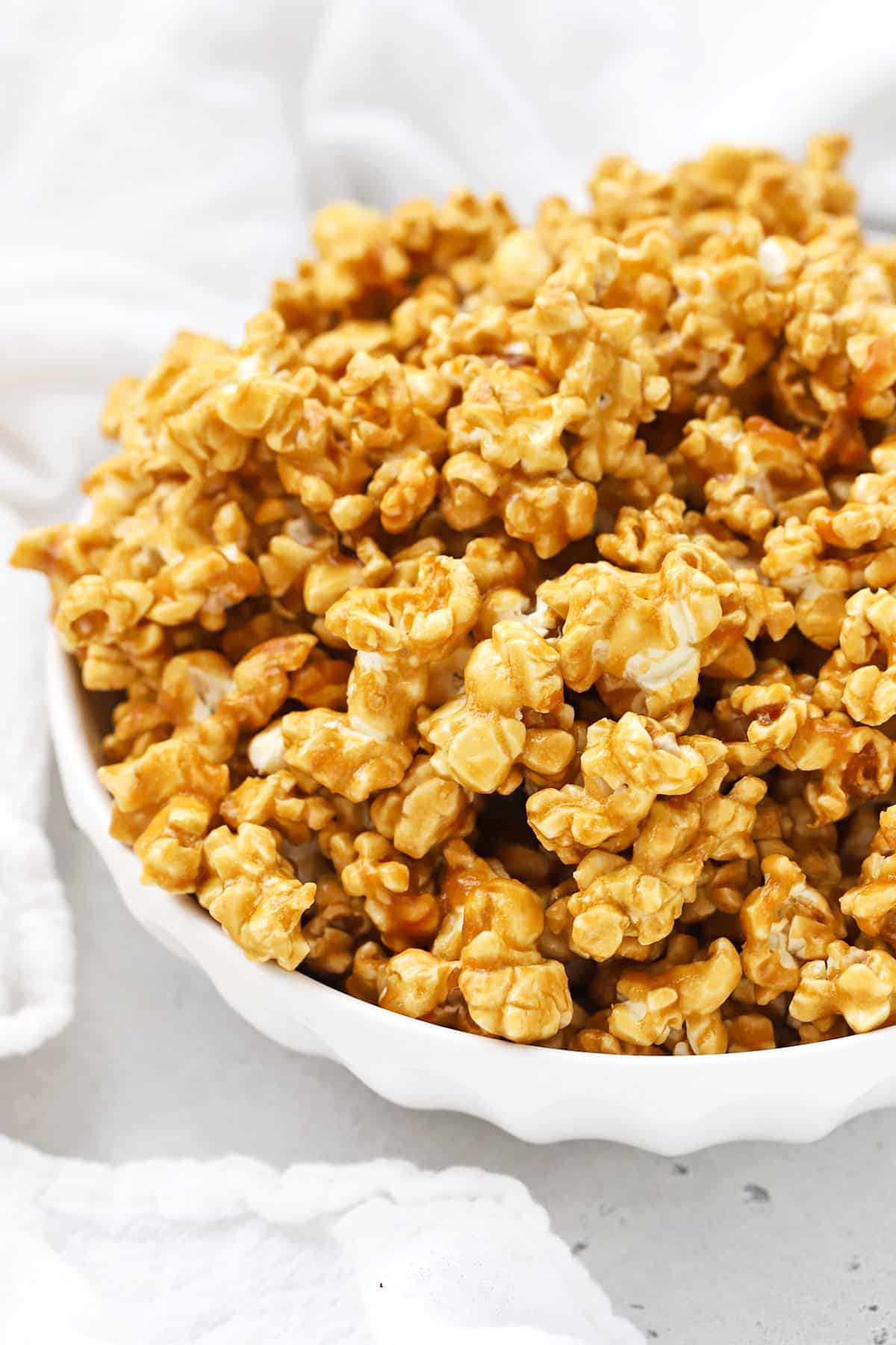 Front view of a large white bowl of homemade caramel corn
