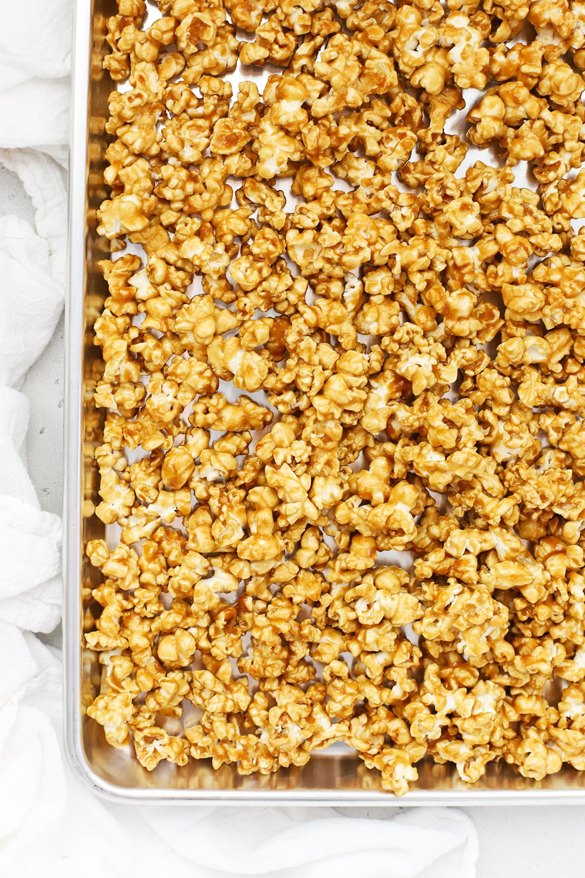 Overhead view of a sheet pan of caramel corn fresh from the oven