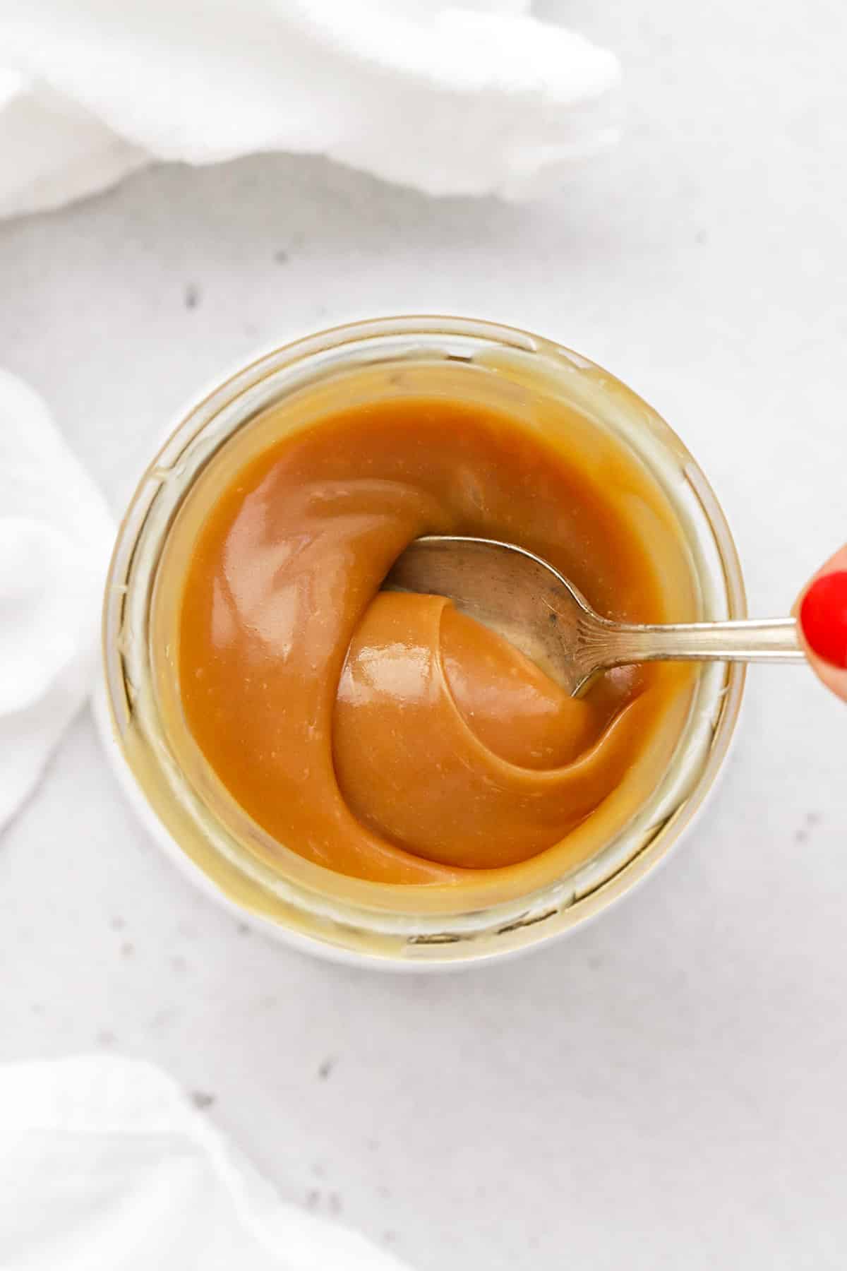 Using a spoon to stir easy homemade caramel sauce