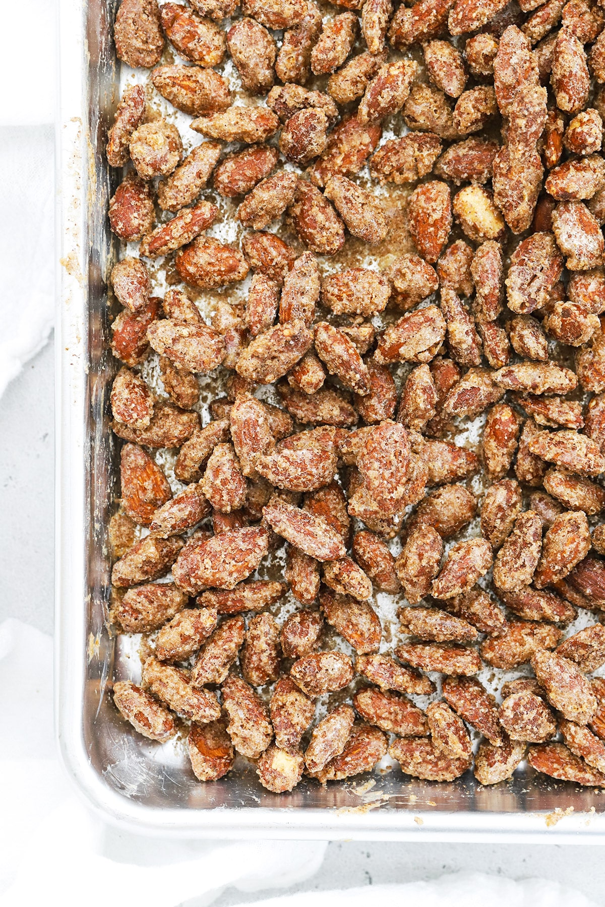 Overhead view of finished roasted cinnamon almonds cooling on the baking sheet
