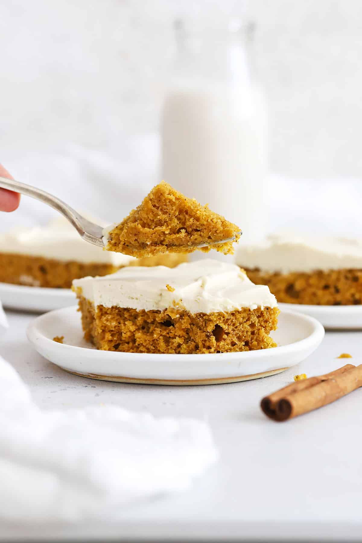 A fork getting a bite of gluten-free pumpkin bars with whipped cream cheese frosting