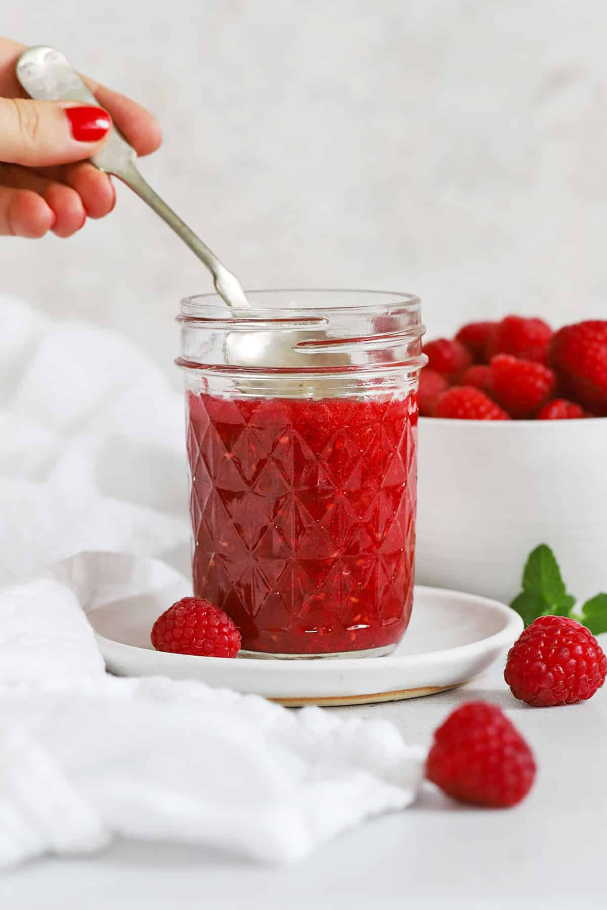 Front view of a jar of low sugar raspberry freezer jam