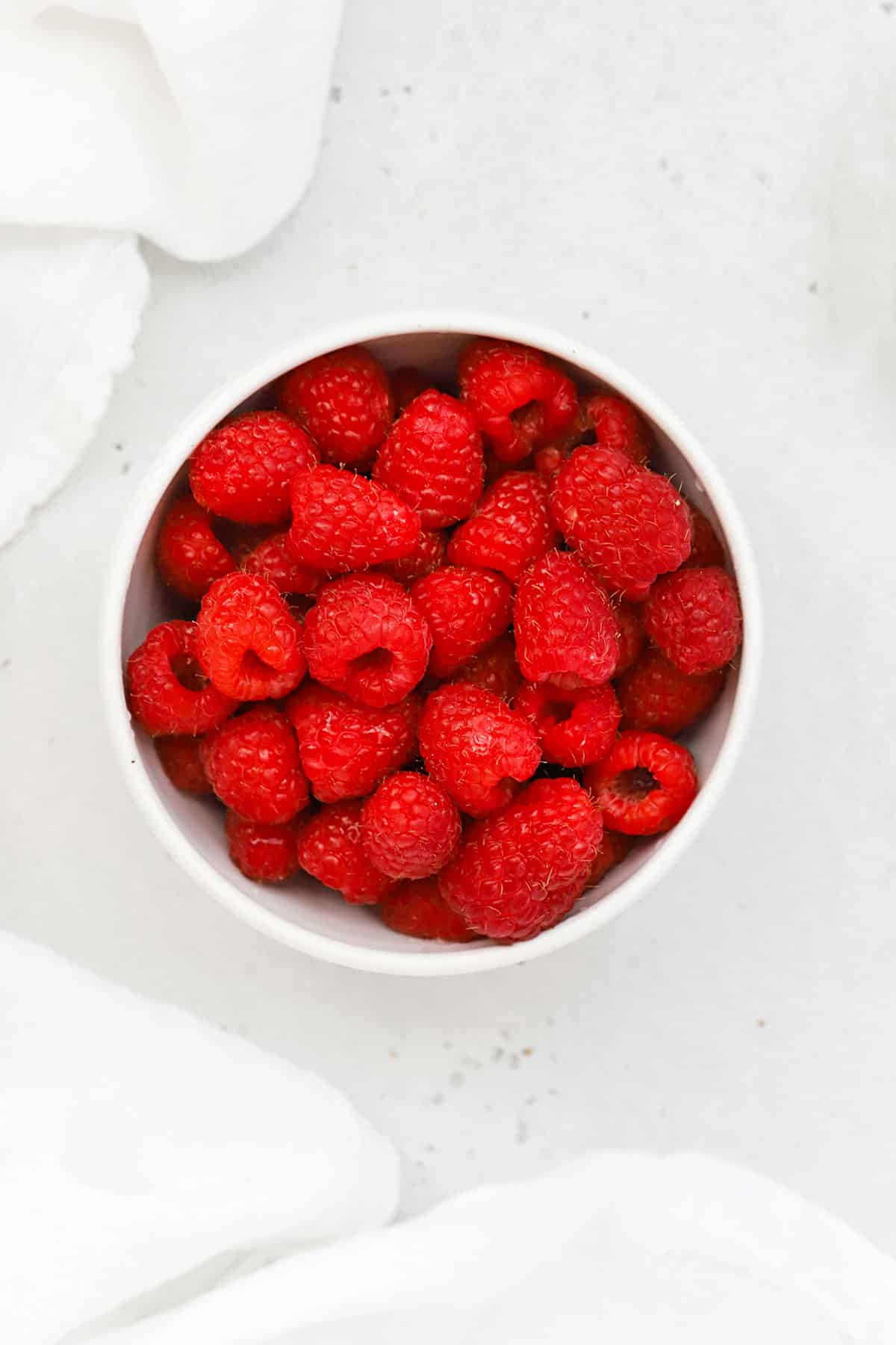 Overhead view of a bowl of red, ripe raspberries
