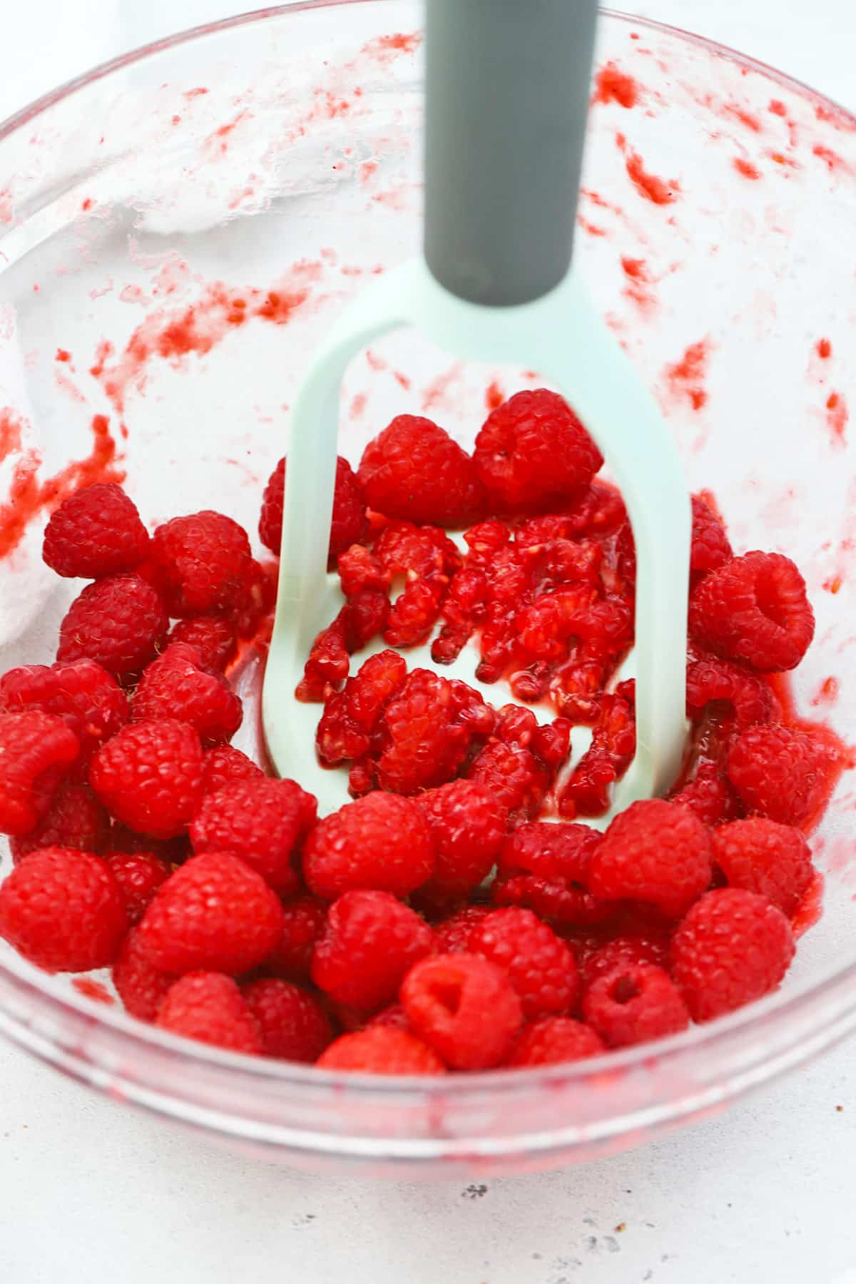 Mashing raspberries for homemade freezer jam