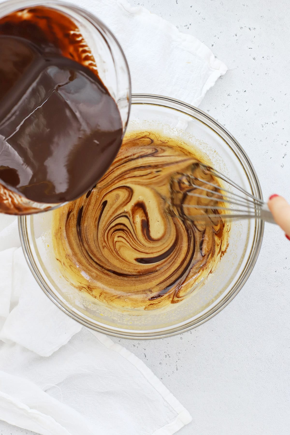 Whisking melted chocolate and butter into eggs and sugar