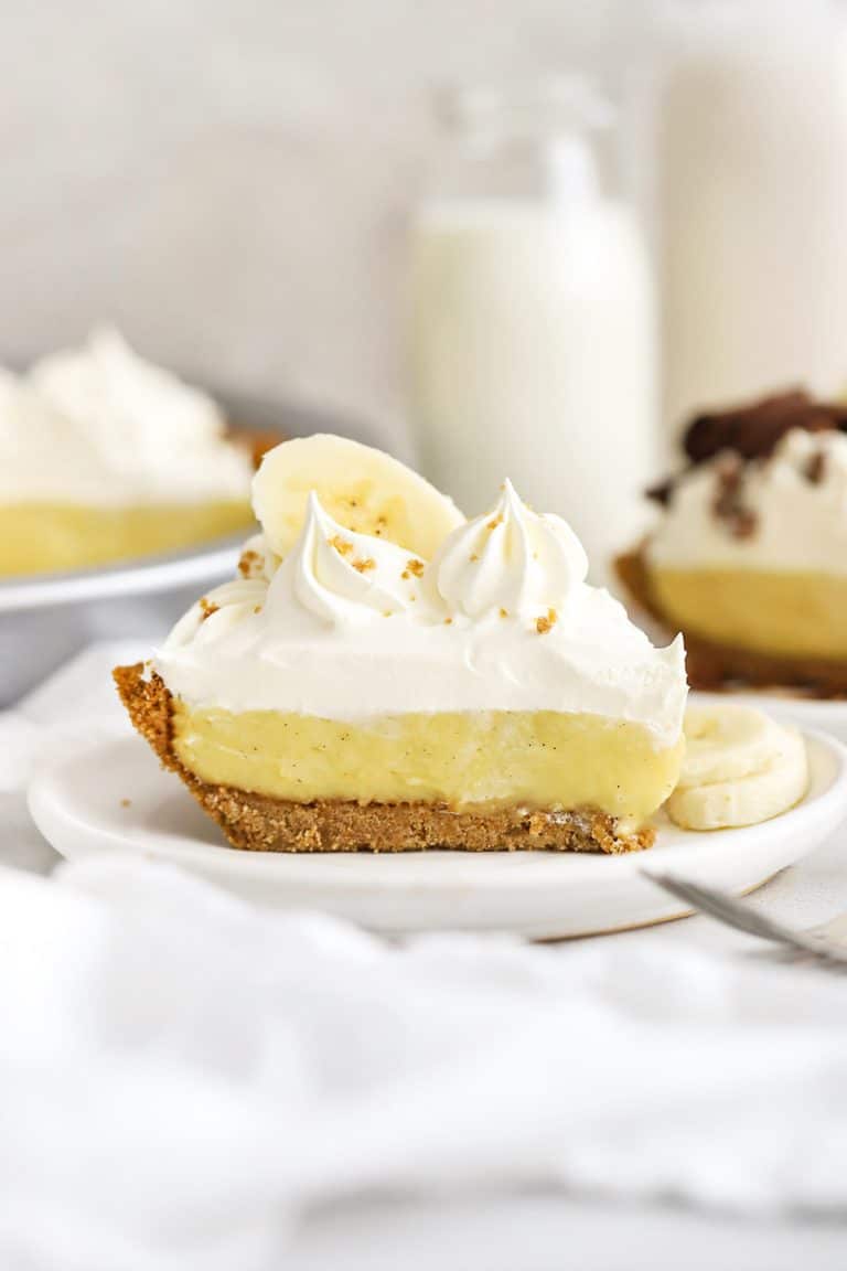 Front view of a slice of gluten-free banana cream pie topped with whipped cream and banana slices