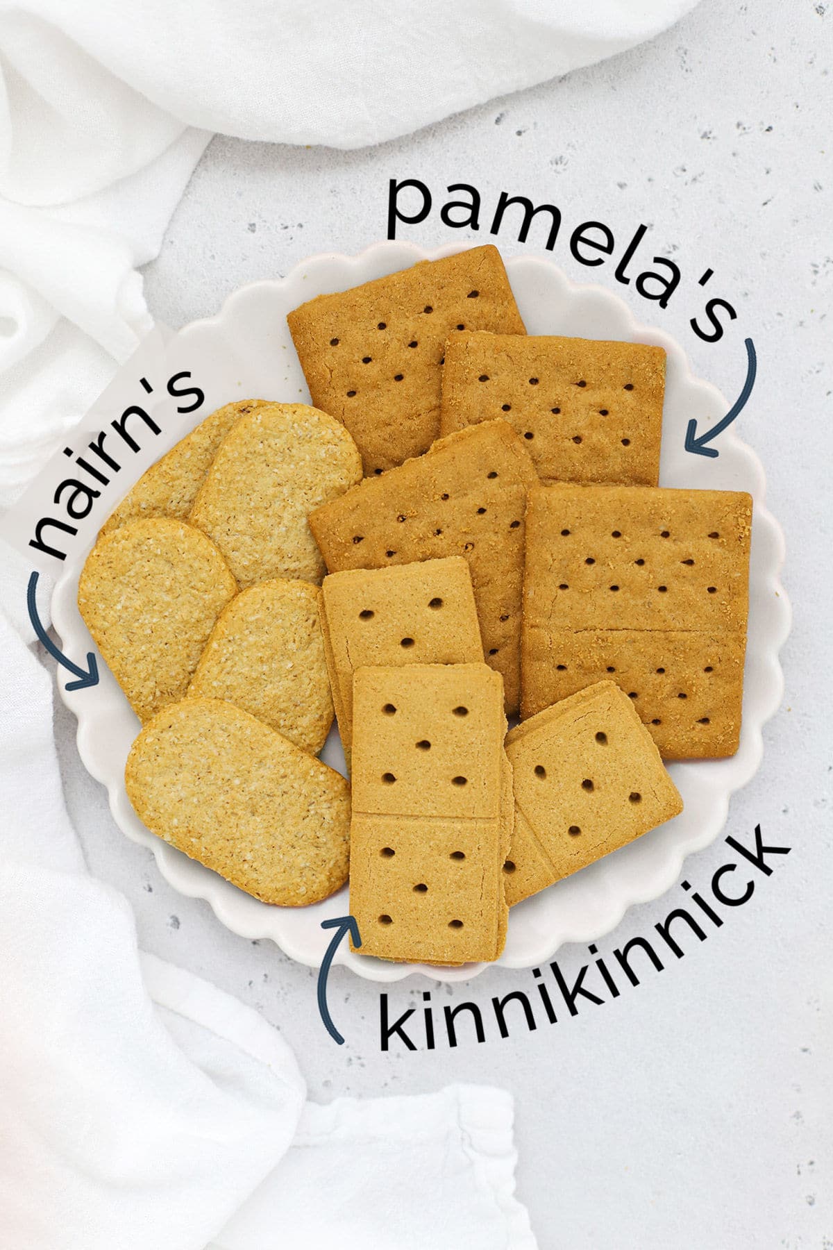 Overhead view of three kinds of gluten-free graham crackers on a white scallop plate