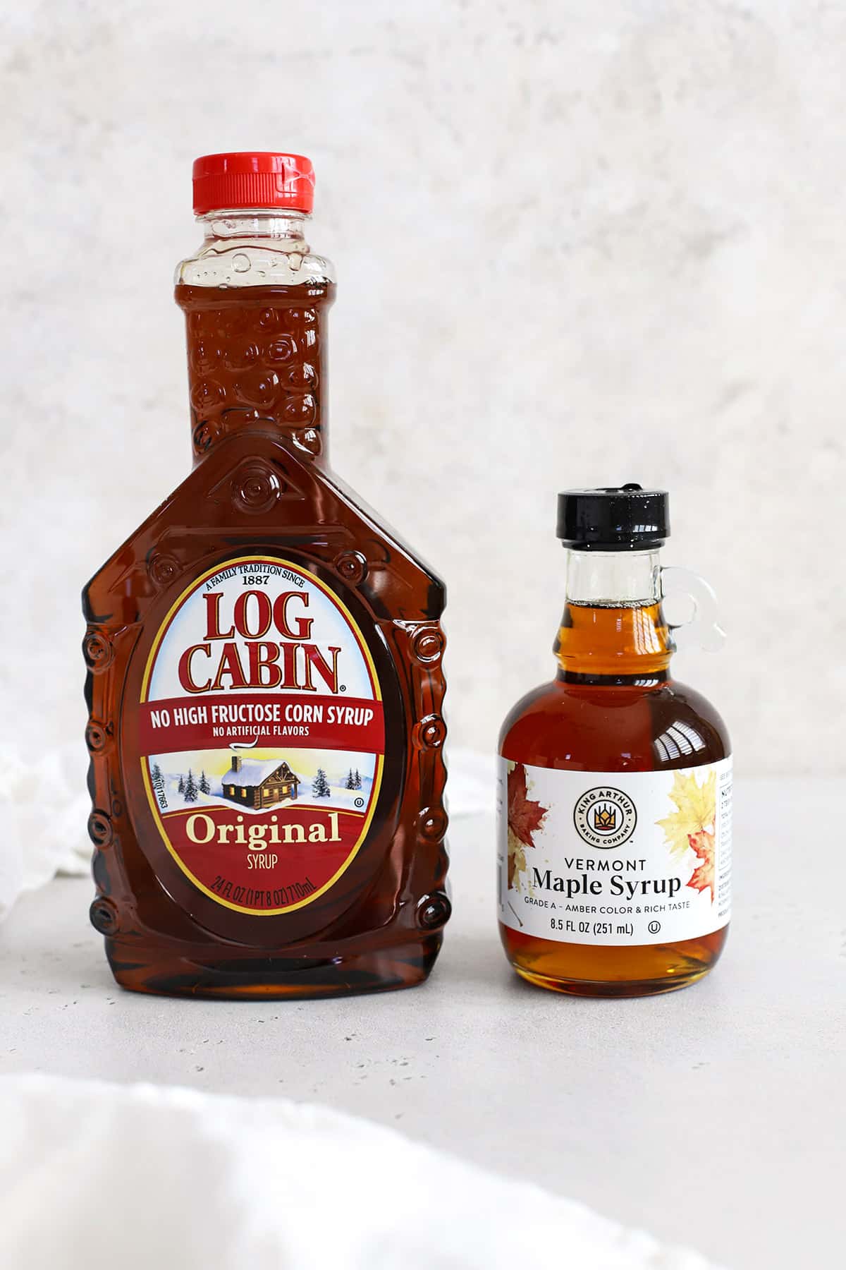 Front view of a bottle of pancake syrup and a bottle of pure maple syrup