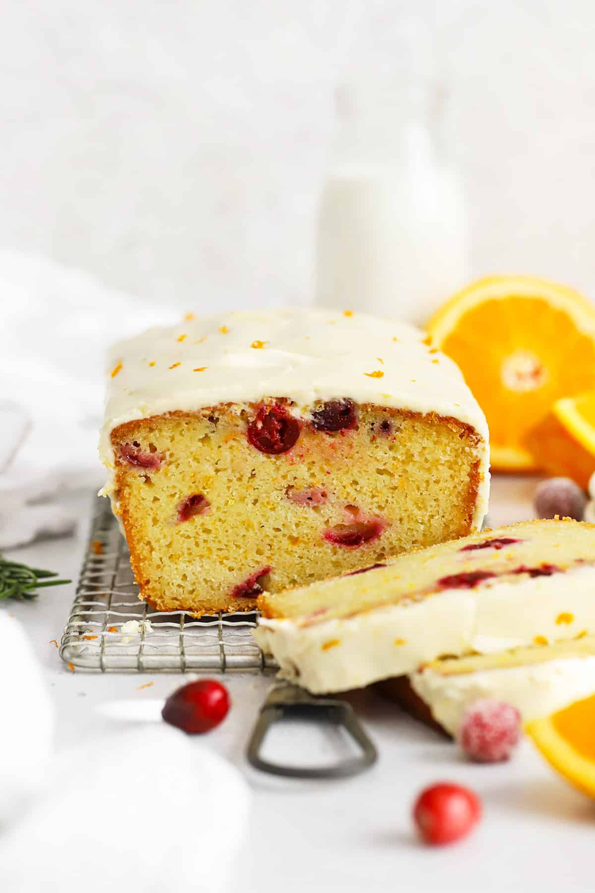Front view of gluten-free orange cranberry loaf cake sliced, so you can see the soft, fluffy texture inside