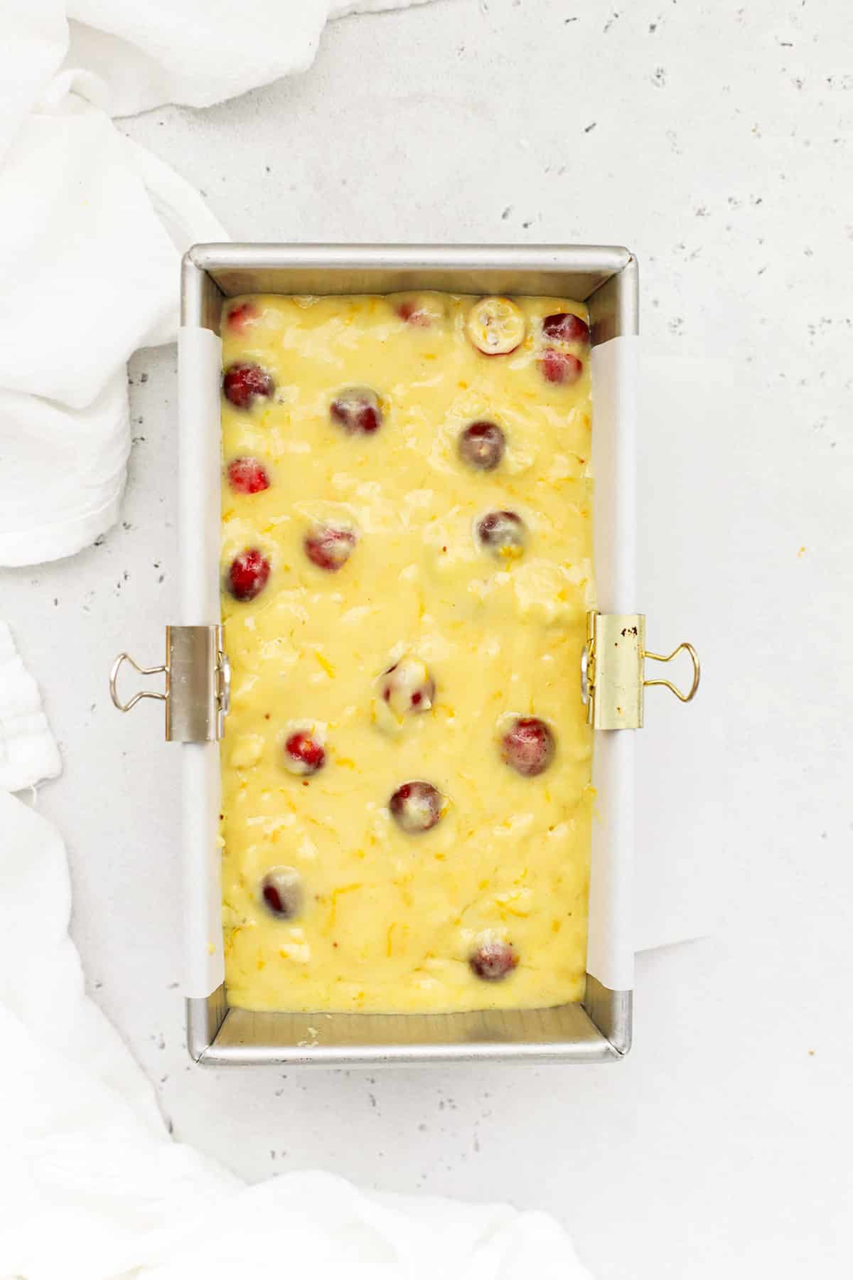 Overhead view of gluten-free orange cranberry cake in a loaf pan ready to go into the oven