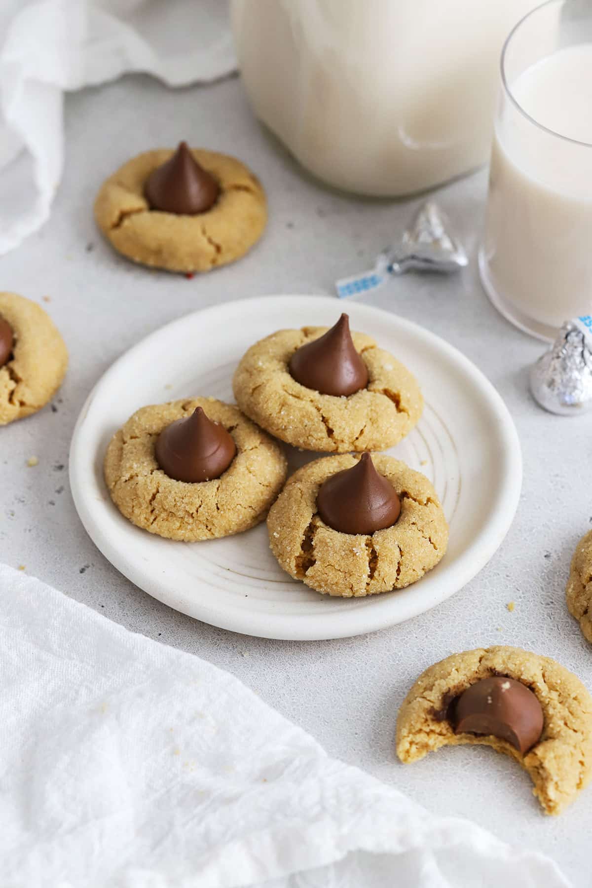 Three gluten-free peanut butter blossom cookies on a white plate