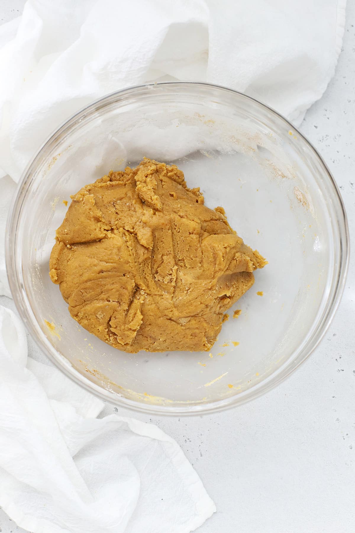 Gluten-free pumpkin snickerdoodle cookie dough in a large glass mixing bowl