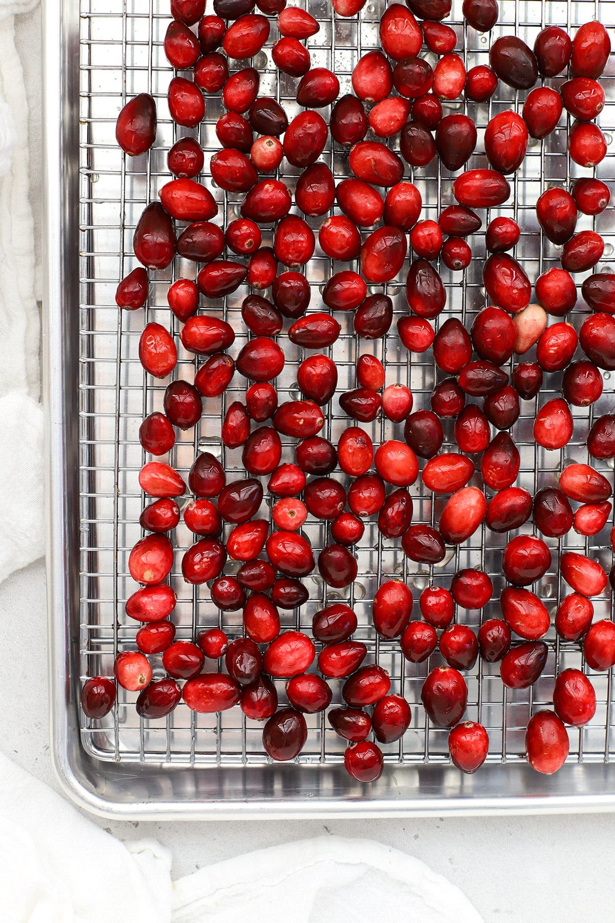 Cranberries coated with simple syrup cooling on a drying rack