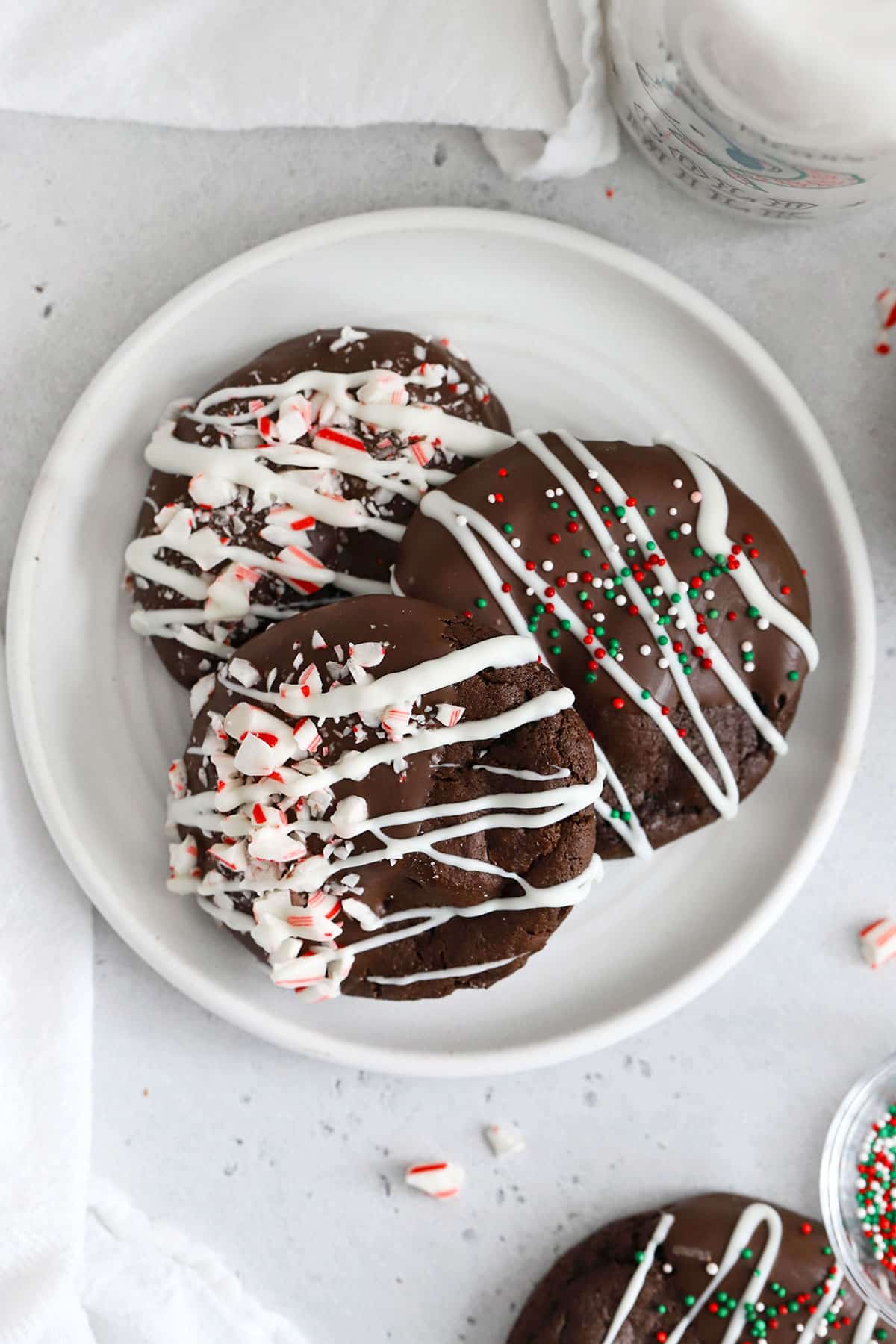 Three gluten-free chocolate candy cane cookies on a white plate