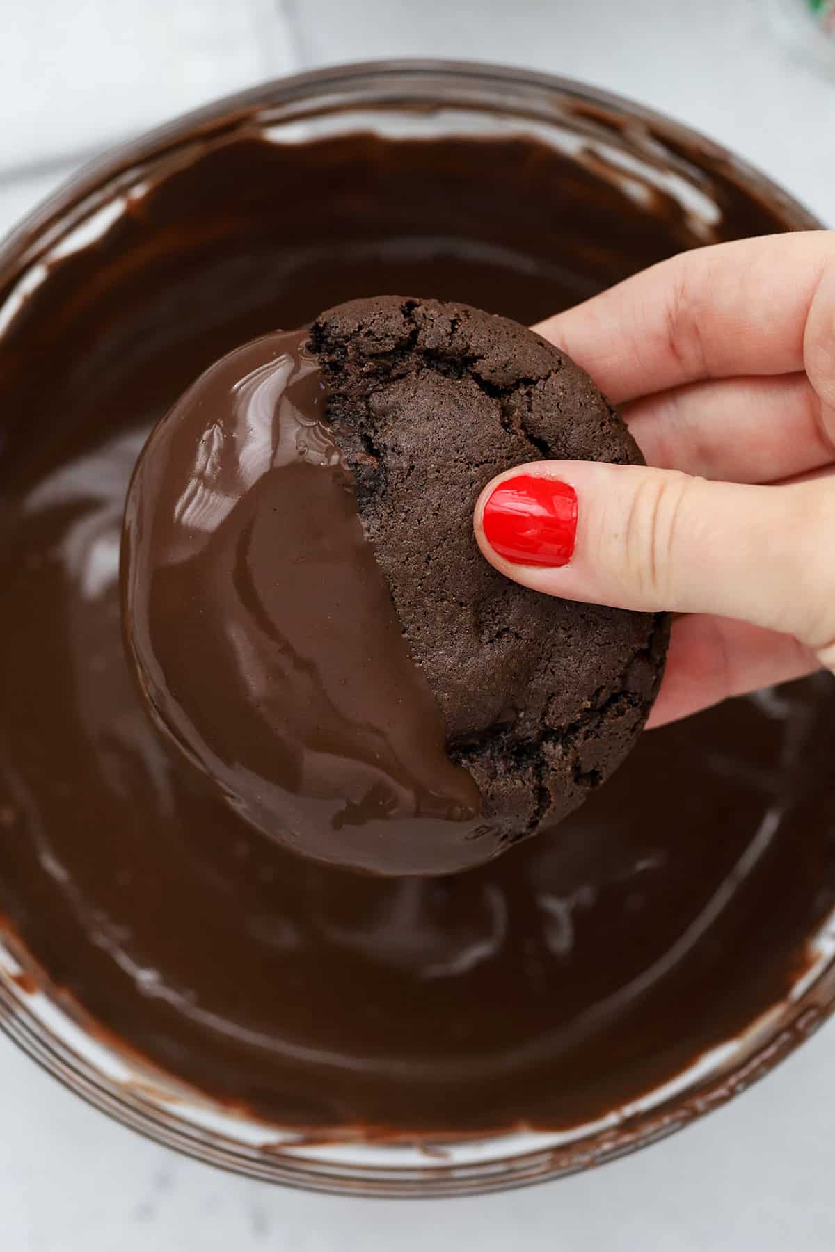 Dipping a chocolate peppermint cookie in melted chocolate
