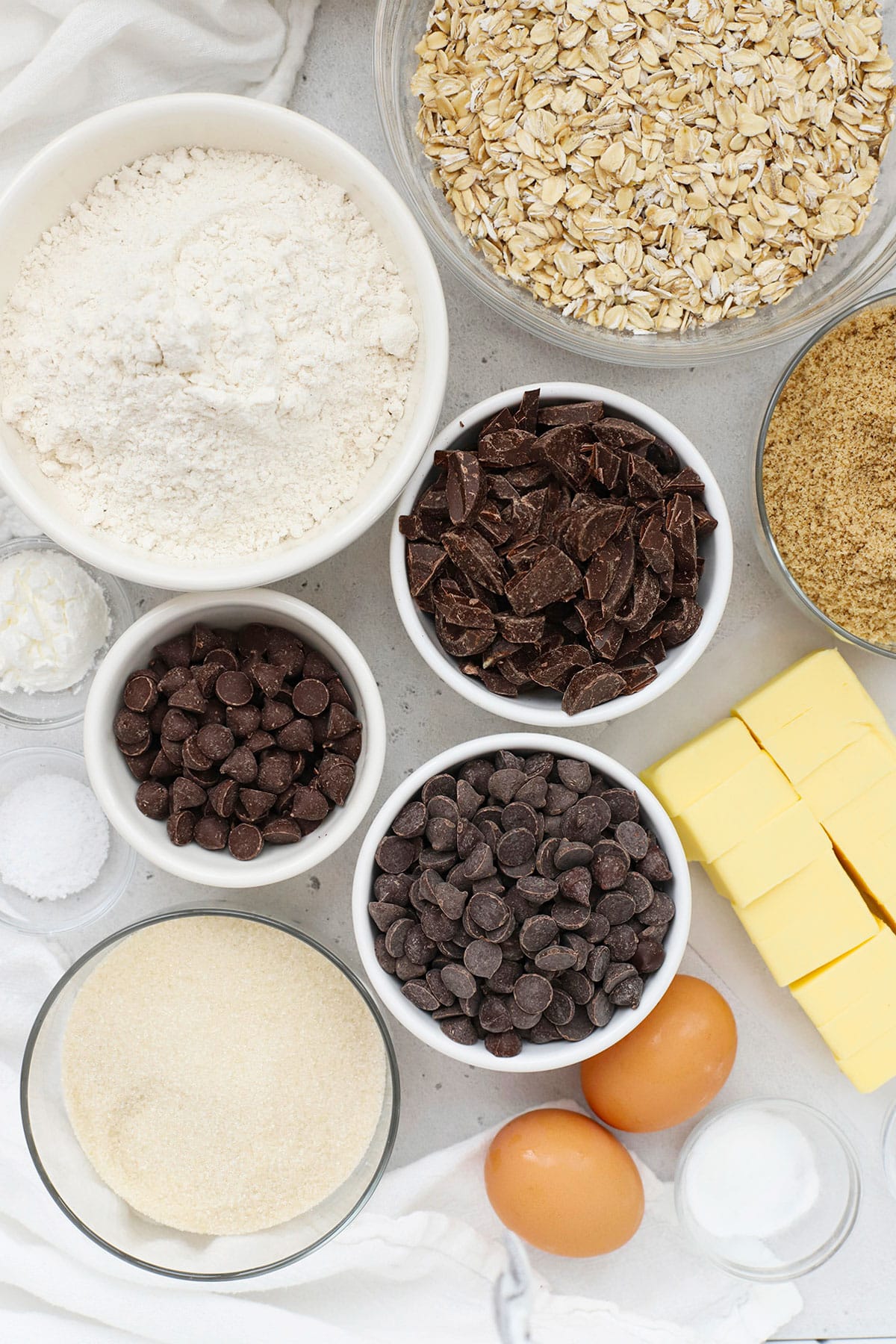 Ingredients for gluten-free oatmeal chocolate chip cookies in small white bowls