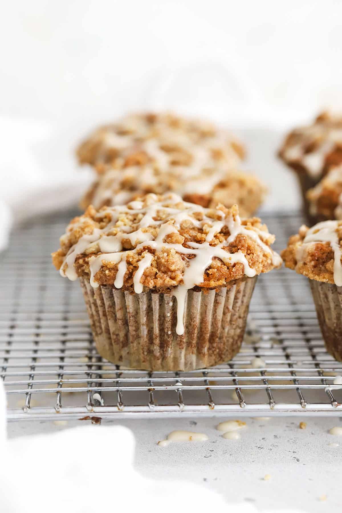 Gluten-Free Banana Crumb Muffin With cinnamon Streusel and maple glaze on a wire rack