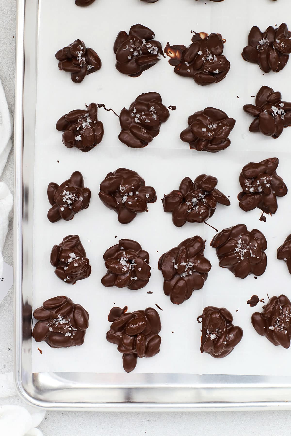 Chocolate almond clusters on a baking sheet lined with parchment