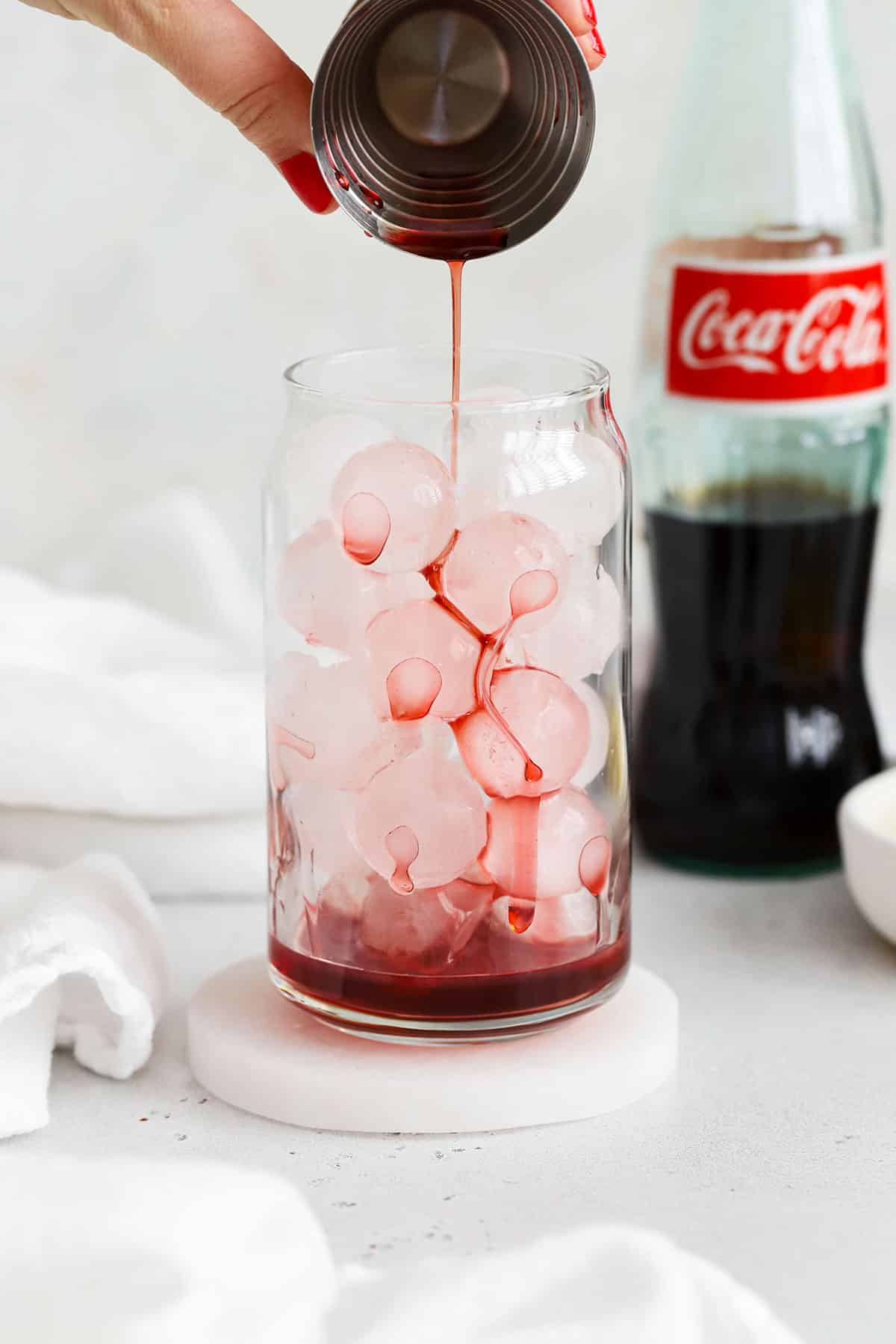 Pouring grenadine syrup over ice