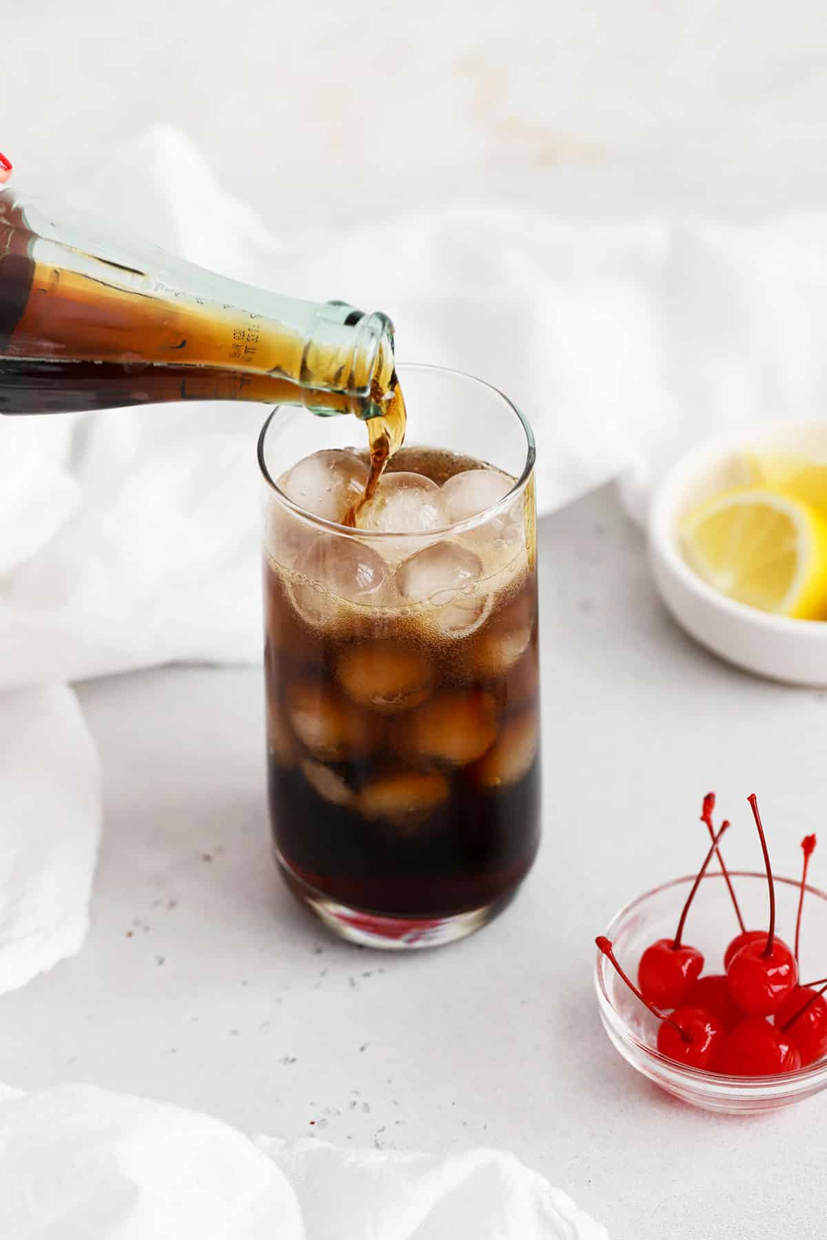 Pouring cola over ice to make a cola mocktail