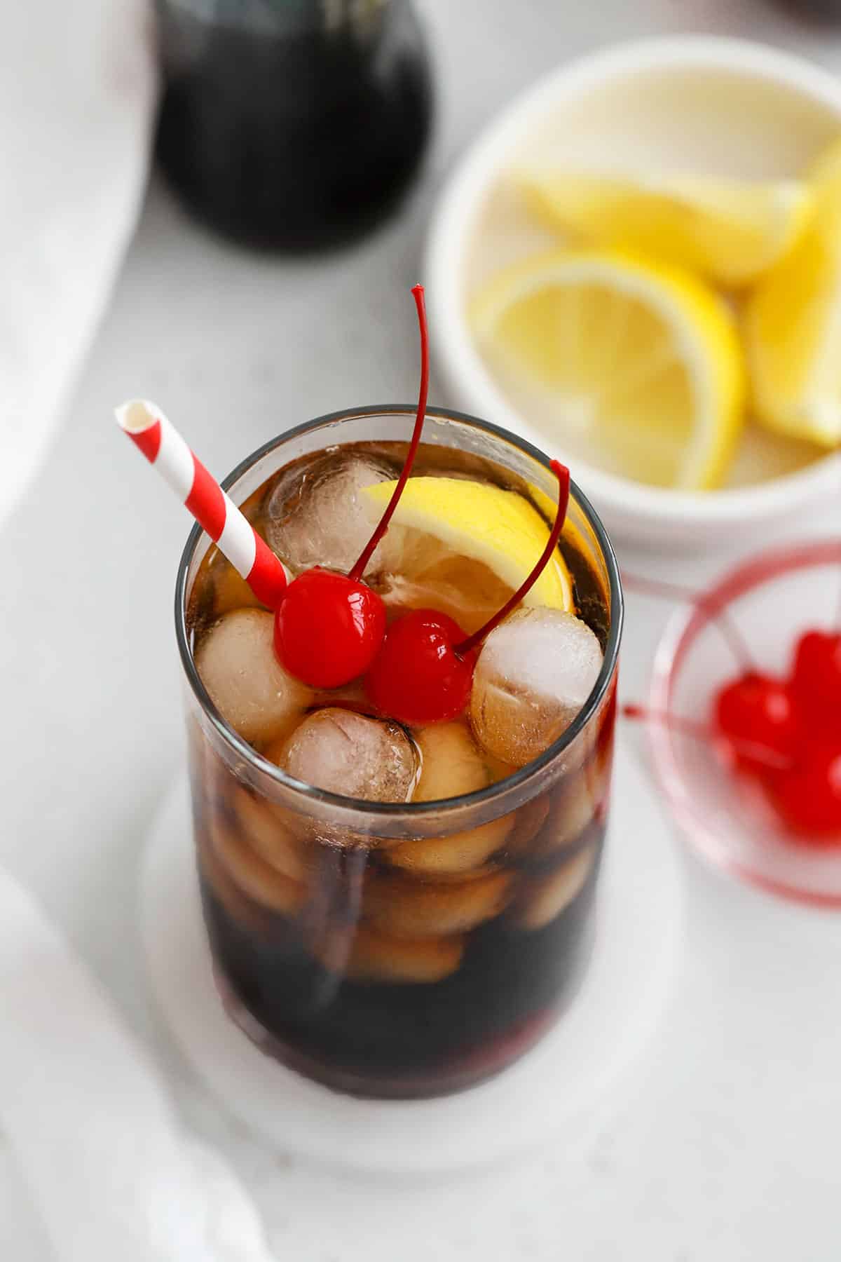 Roy Rogers Drink with maraschino cherries and lemon wedge
