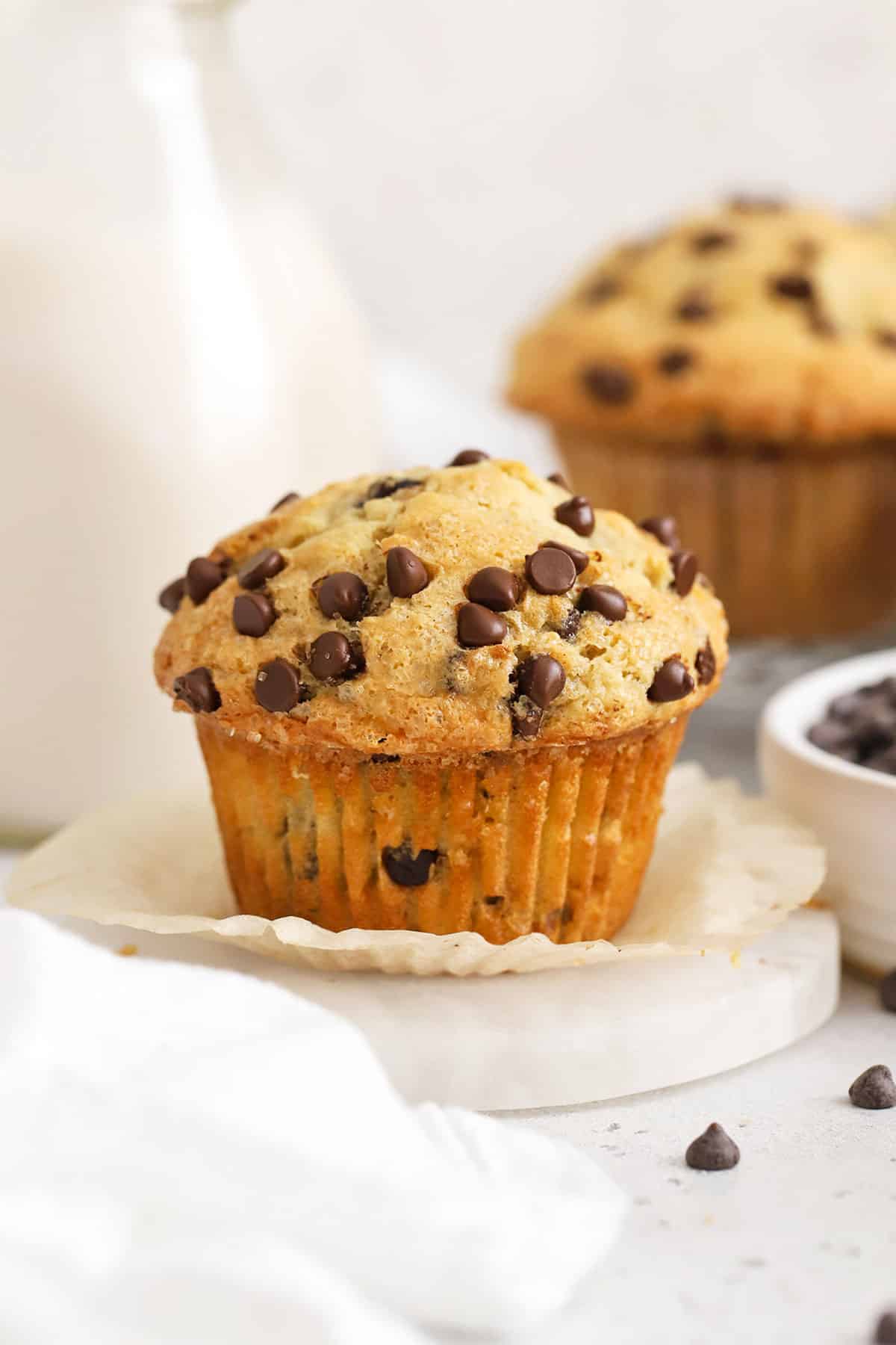 Bakery style gluten-free chocolate chip muffins with a bottle of milk