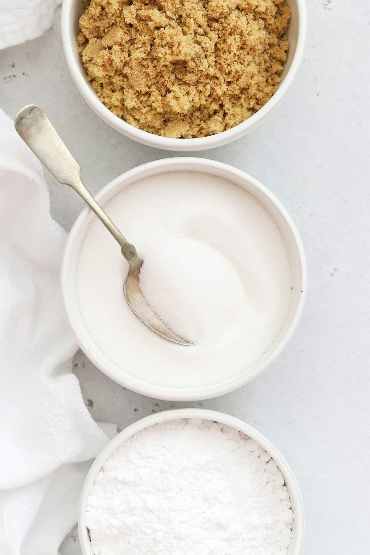 three kinds of sugar in white bowls