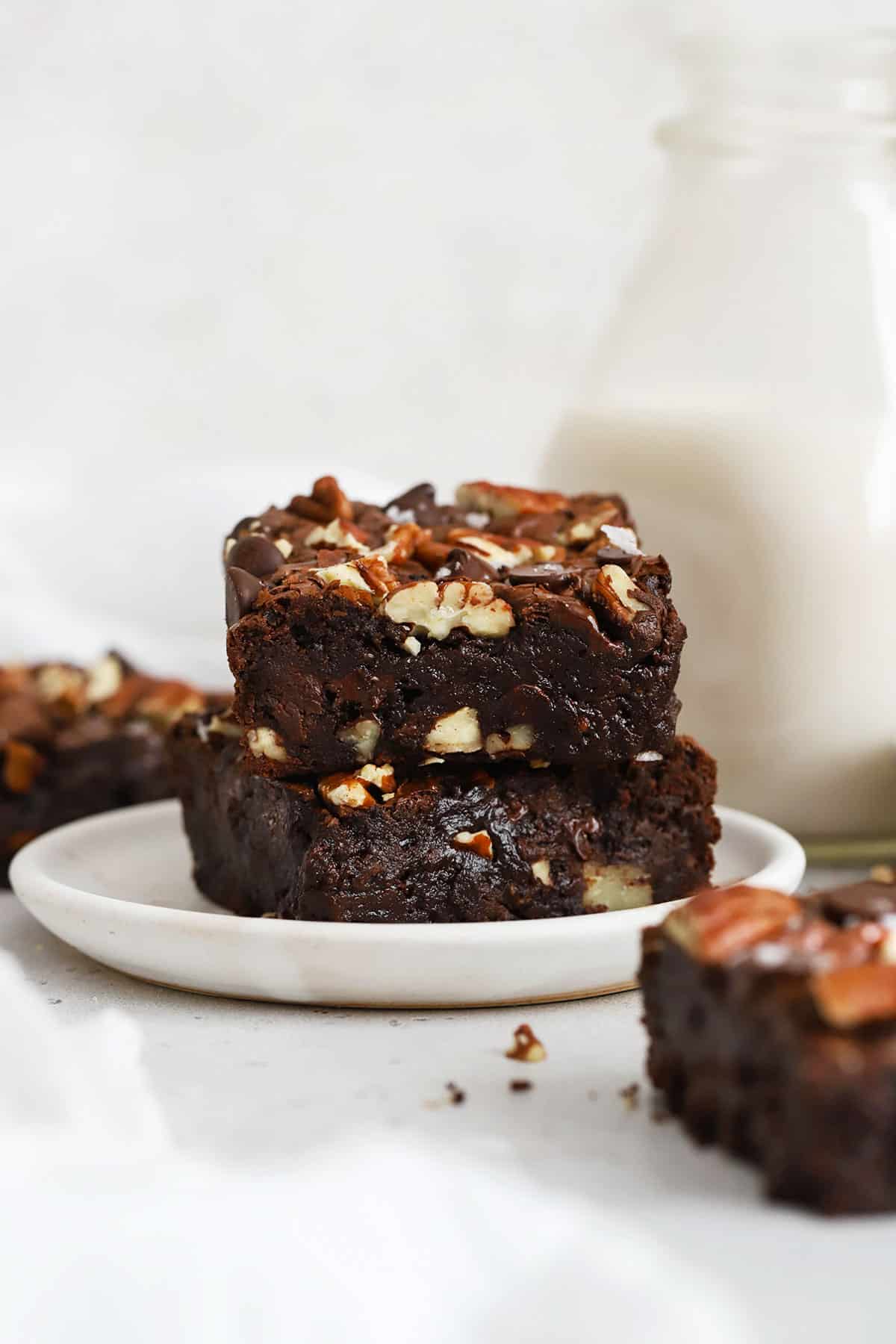 gluten-free pecan brownies stacked on a white plate