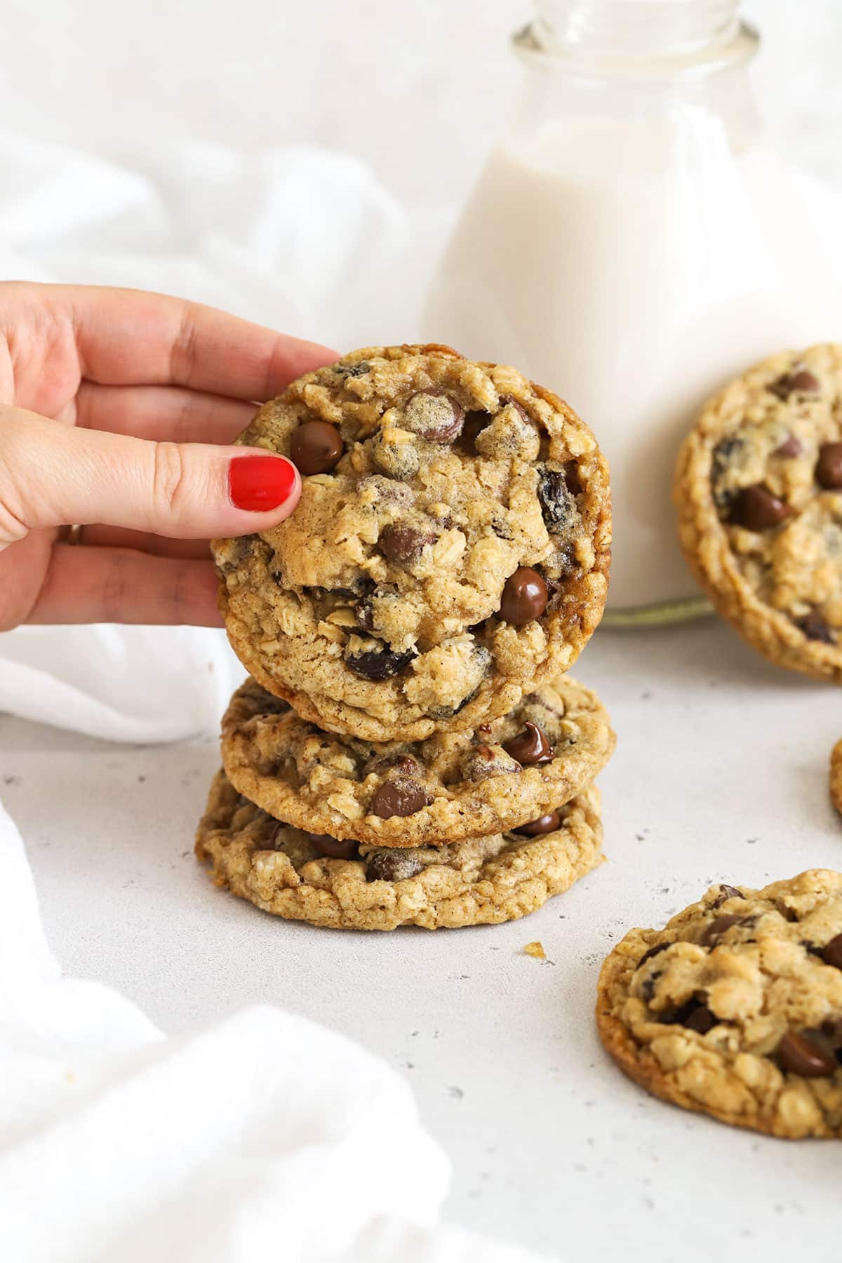 a stack of gluten-free oatmeal raisin chocolate chip cookies on a white background