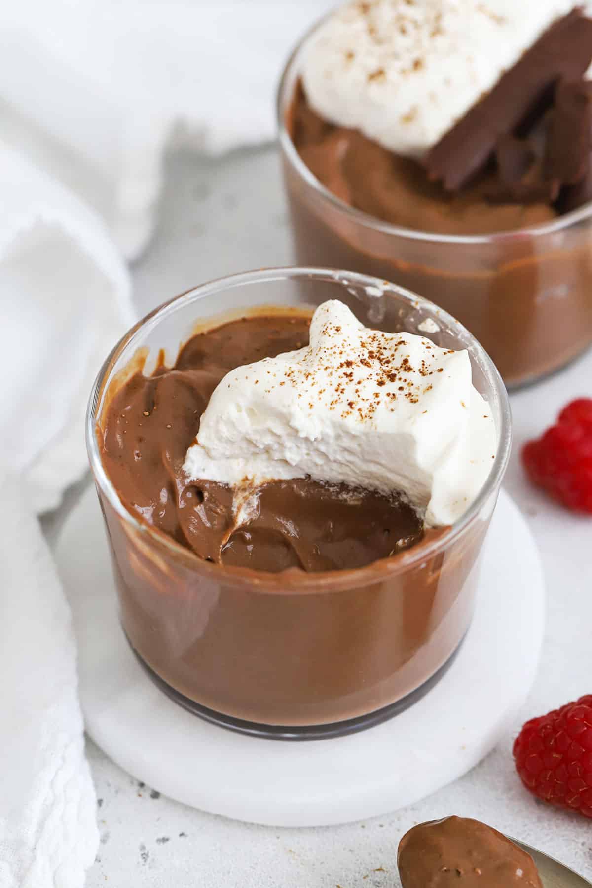 glass bowls of gluten-free chocolate pudding topped with whipped cream
