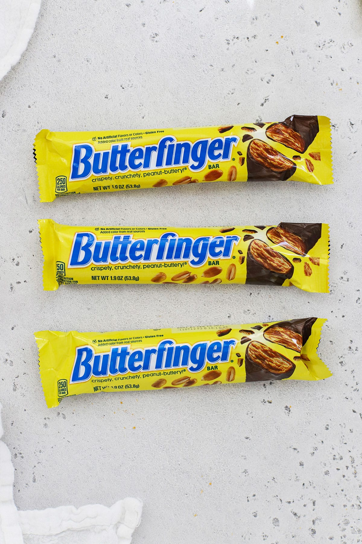 three sizes of Butterfinger candy bars on a white background