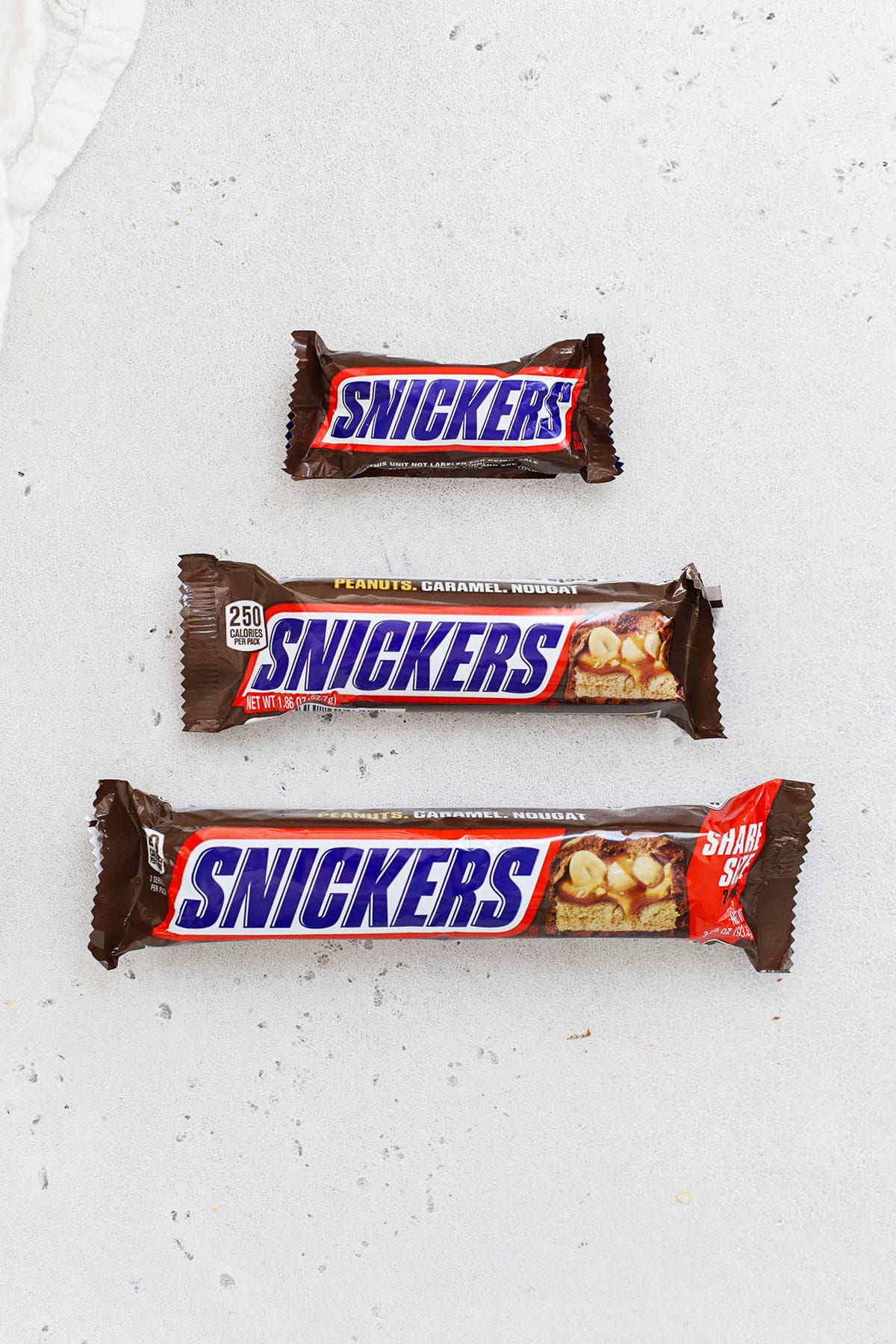 three different sizes of Snickers candy bars