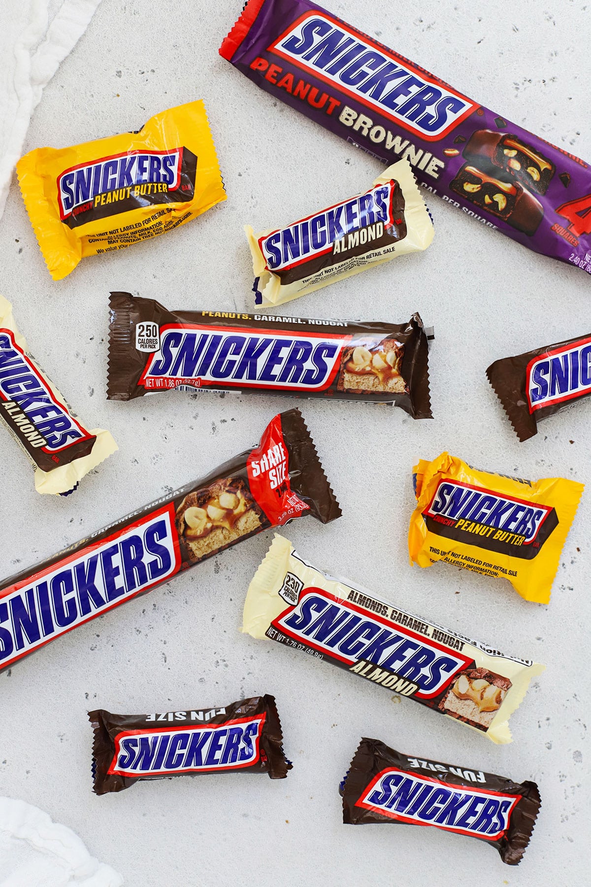 different flavors of Snickers bars arranged on a white background