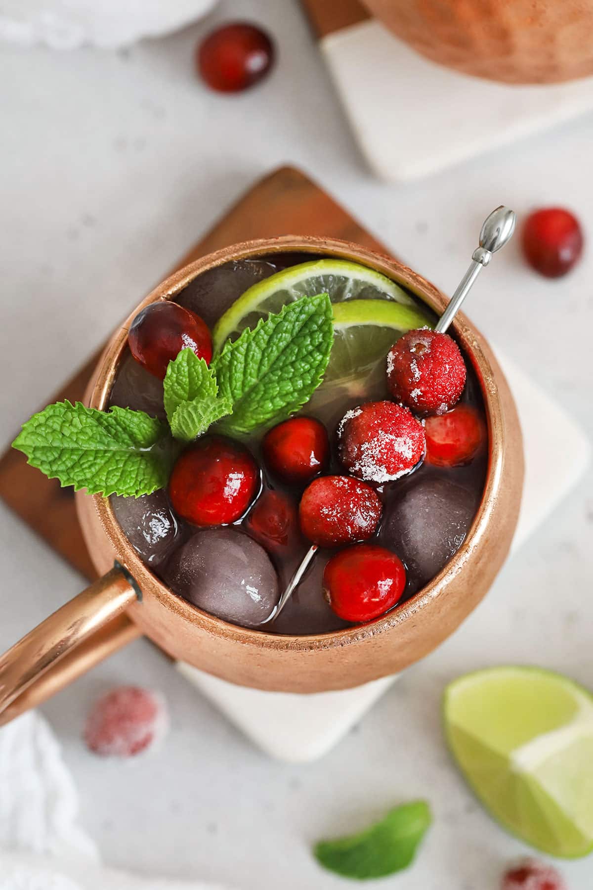 cranberry moscow mule mocktail with ginger beer, cranberries, lime, and mint