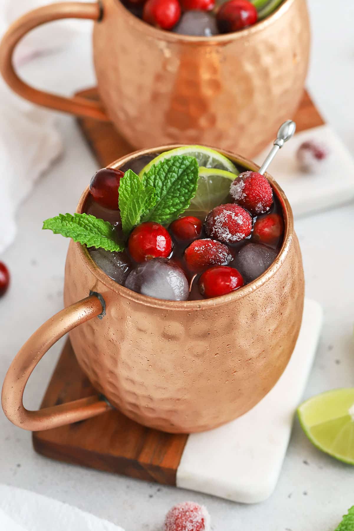 red and green cranberry moscow mule mocktails in copper mugs