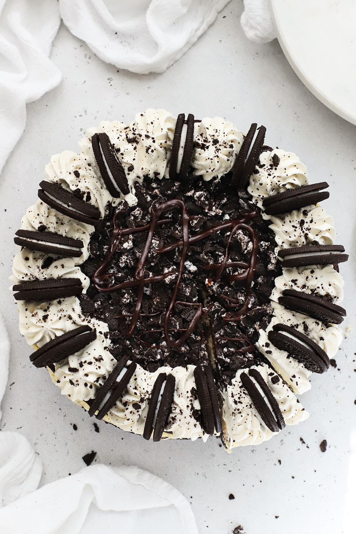 Whole Gluten-Free Oreo Cheesecake Topped With Whipped Cream Swirls, Chocolate Ganache & Oreo Cookies