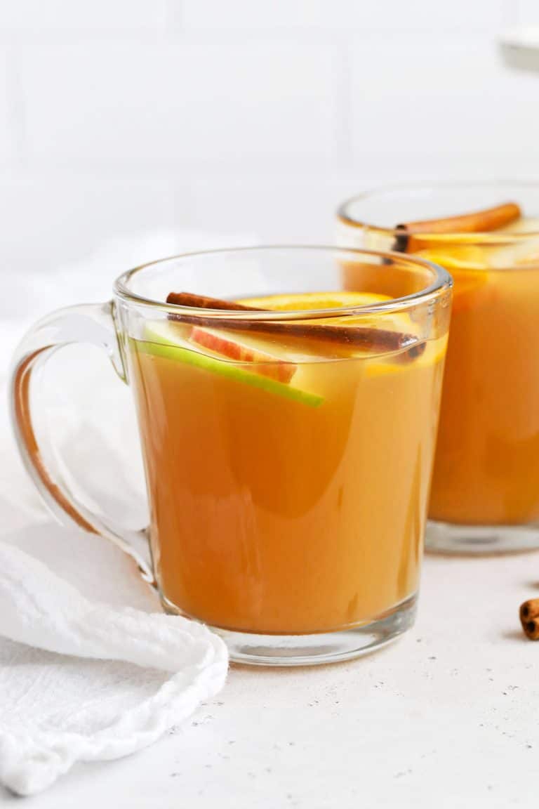 Spiced Cider From One Lovely Life topped with apple slices and cinnamon sticks