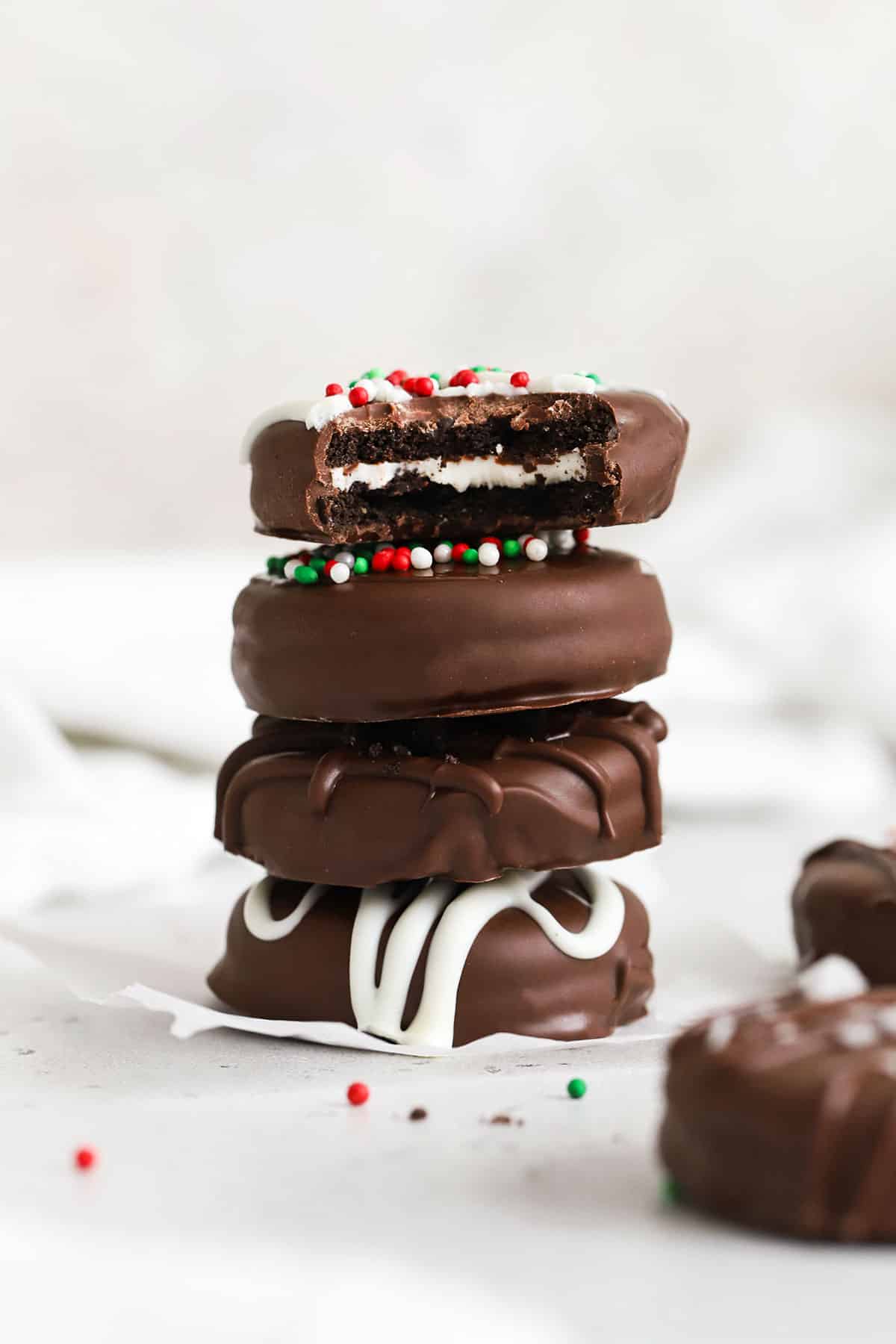 Gluten-Free Chocolate Covered Oreos stacked on a white background