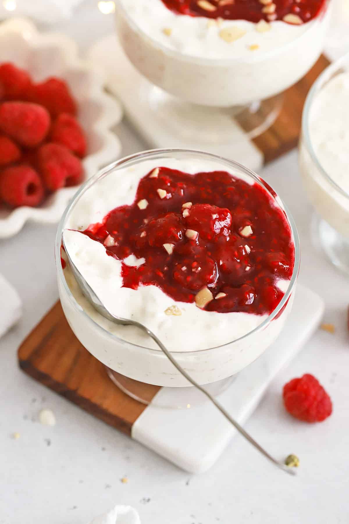 Danish rice pudding in dessert bowls topped with raspberry sauce