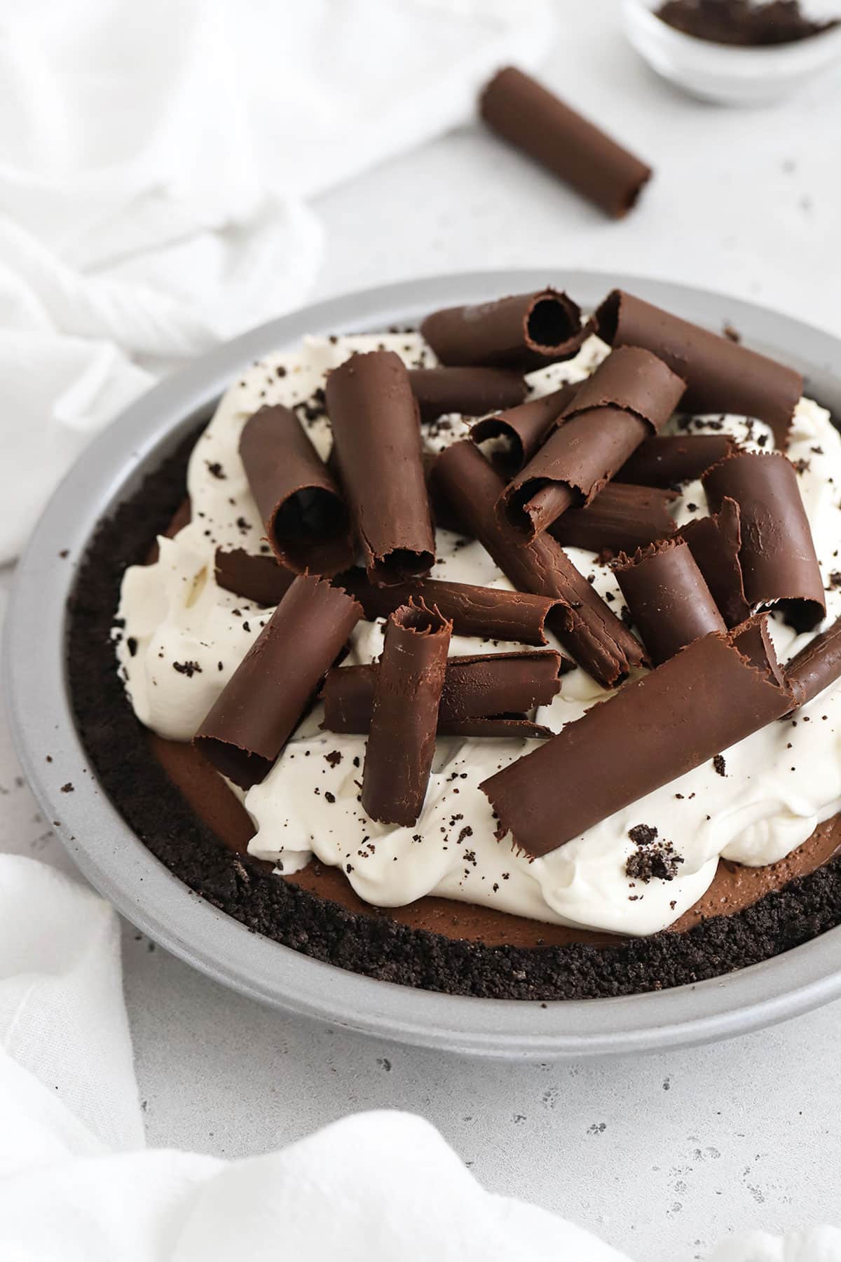 3 layer gluten-free chocolate pie topped with chocolate curls and whipped cream